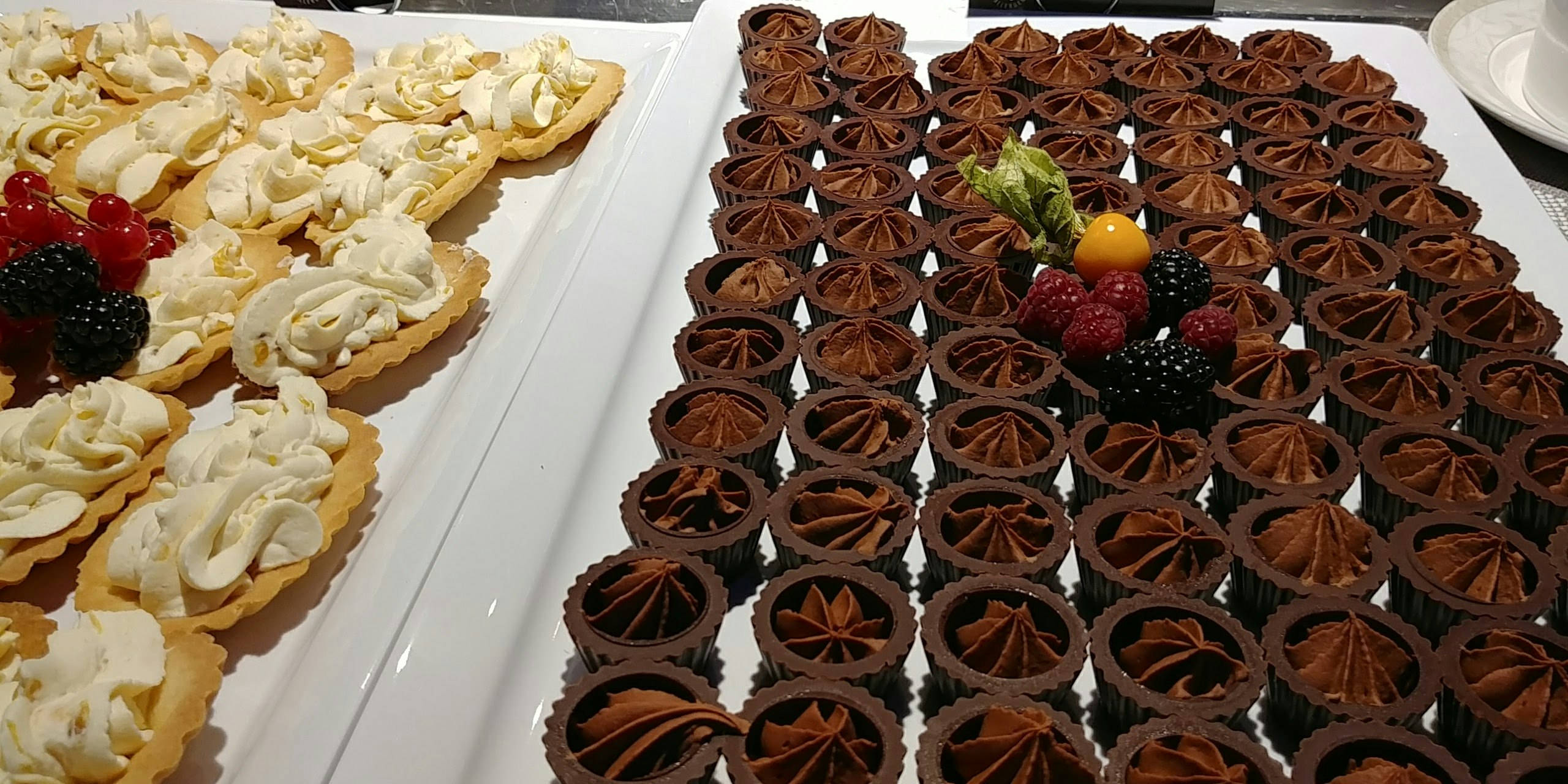 巧克力塔與白色奶油點心擺放在甜點自助的托盤上
