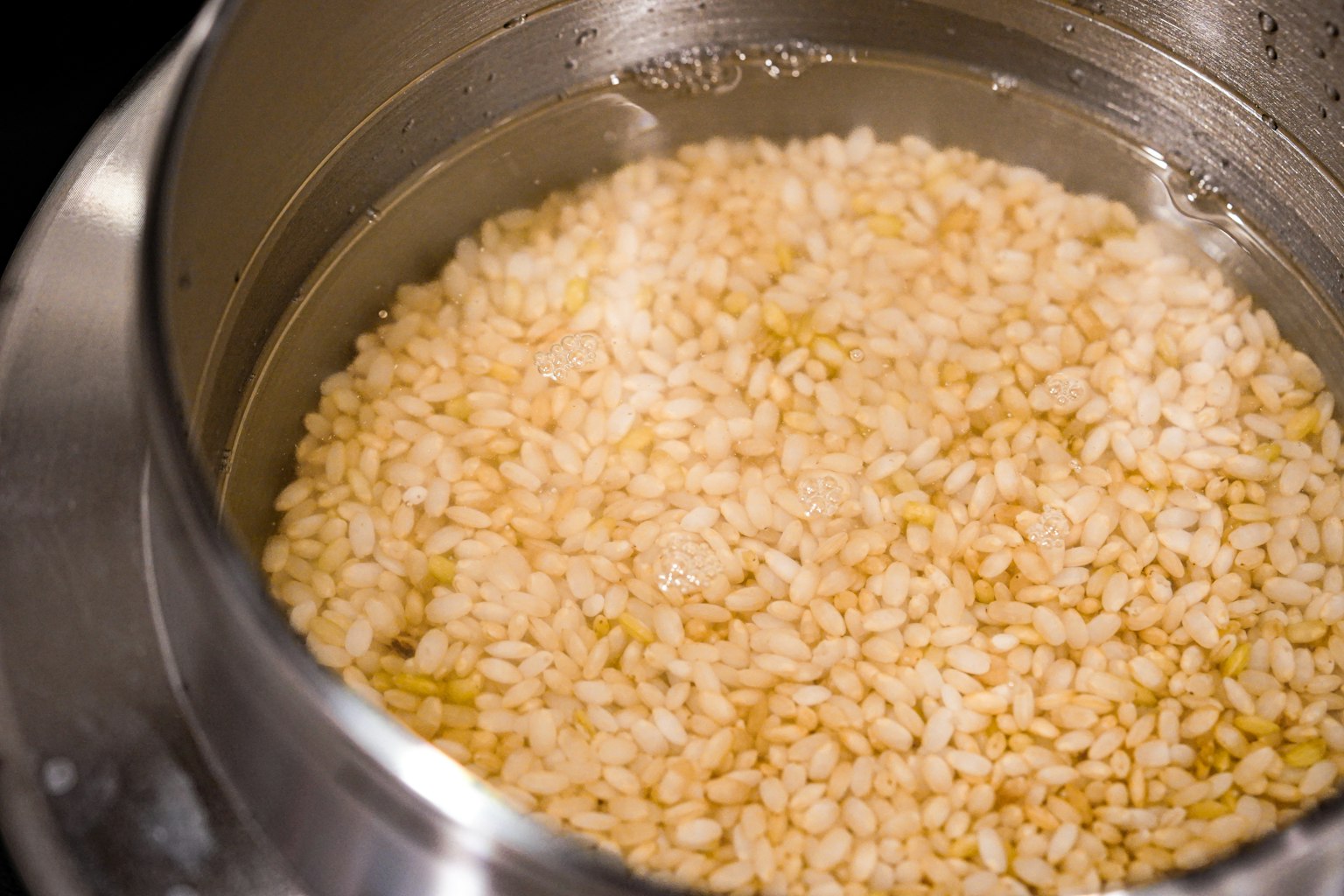 Grains de riz blanc trempant dans l'eau dans une casserole