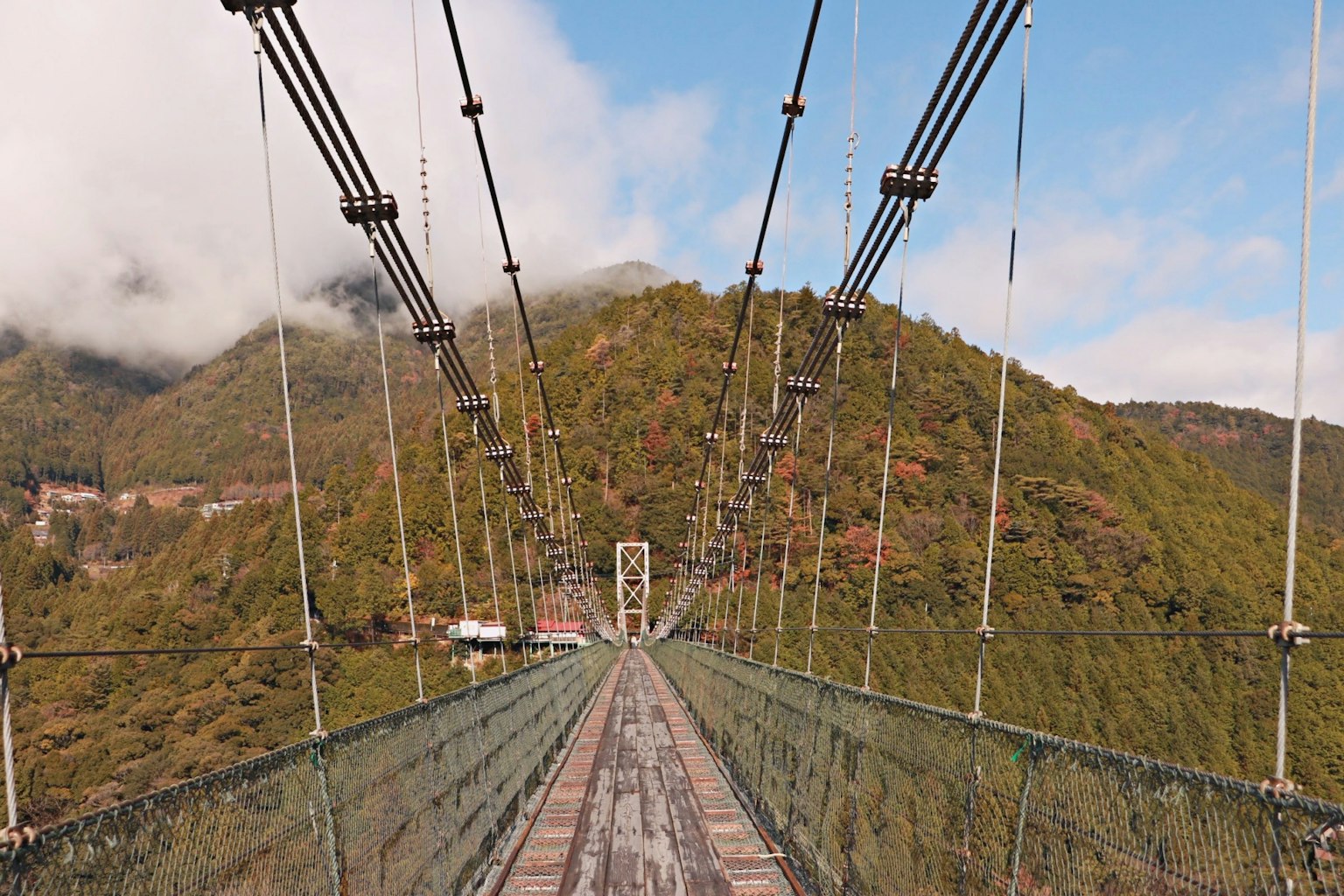 Puente colgante con montañas al fondo