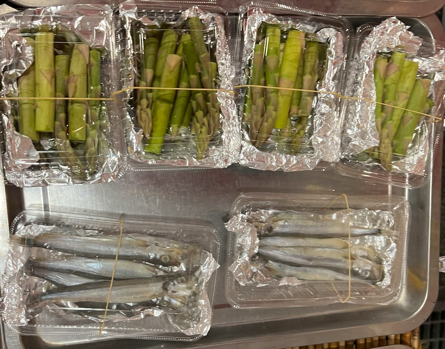 托盤上排列的蘆筍和魚