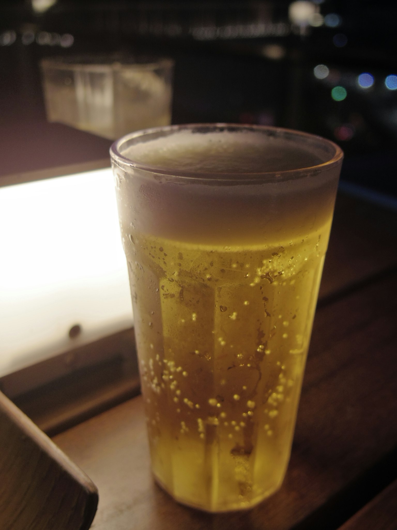 Un vaso de cerveza espumosa sobre un fondo oscuro