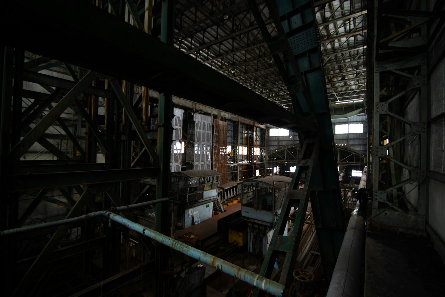 Dark industrial interior showcasing structural beams and machinery