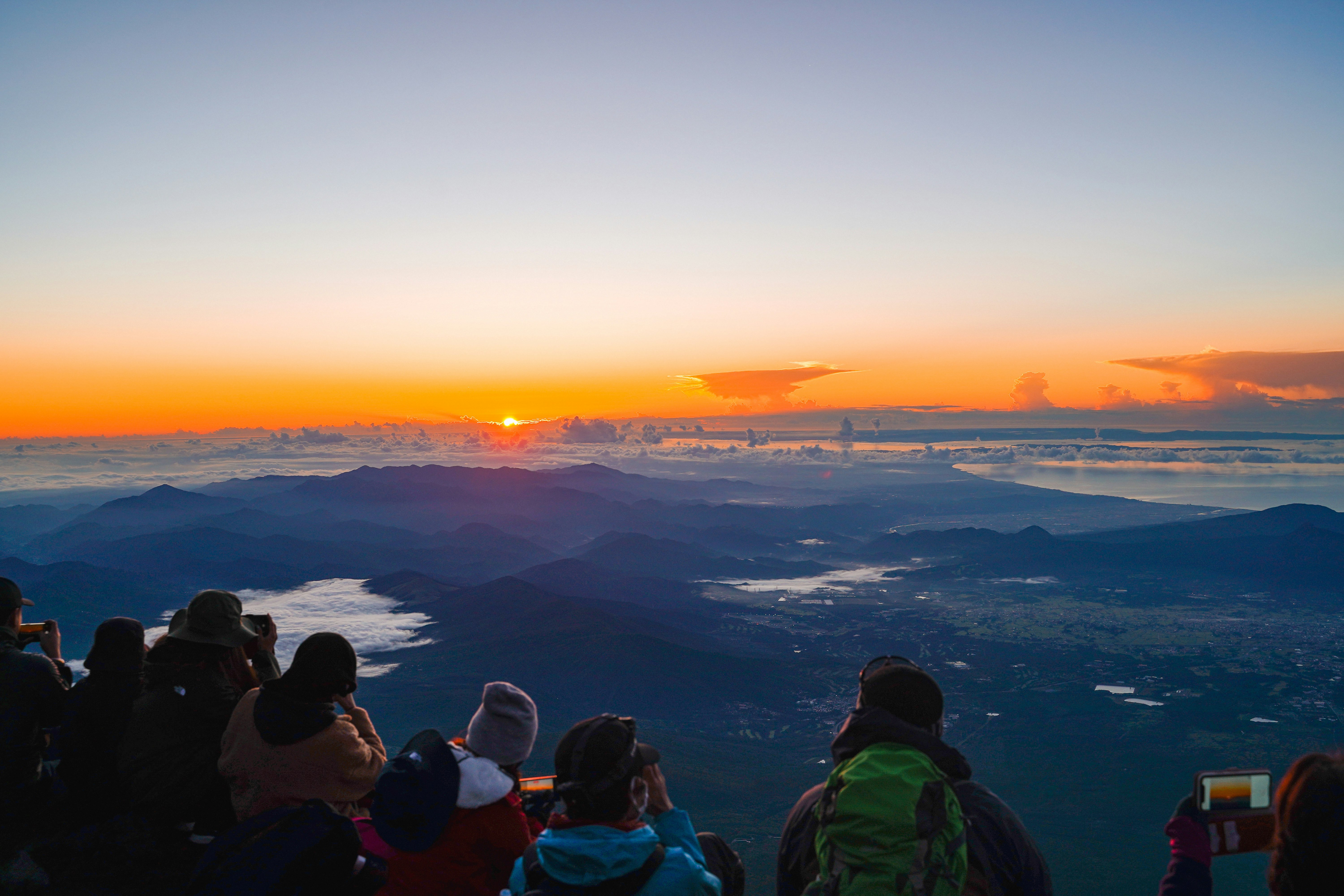 雲海の向こうに広がる山並みと夕焼けの絶景