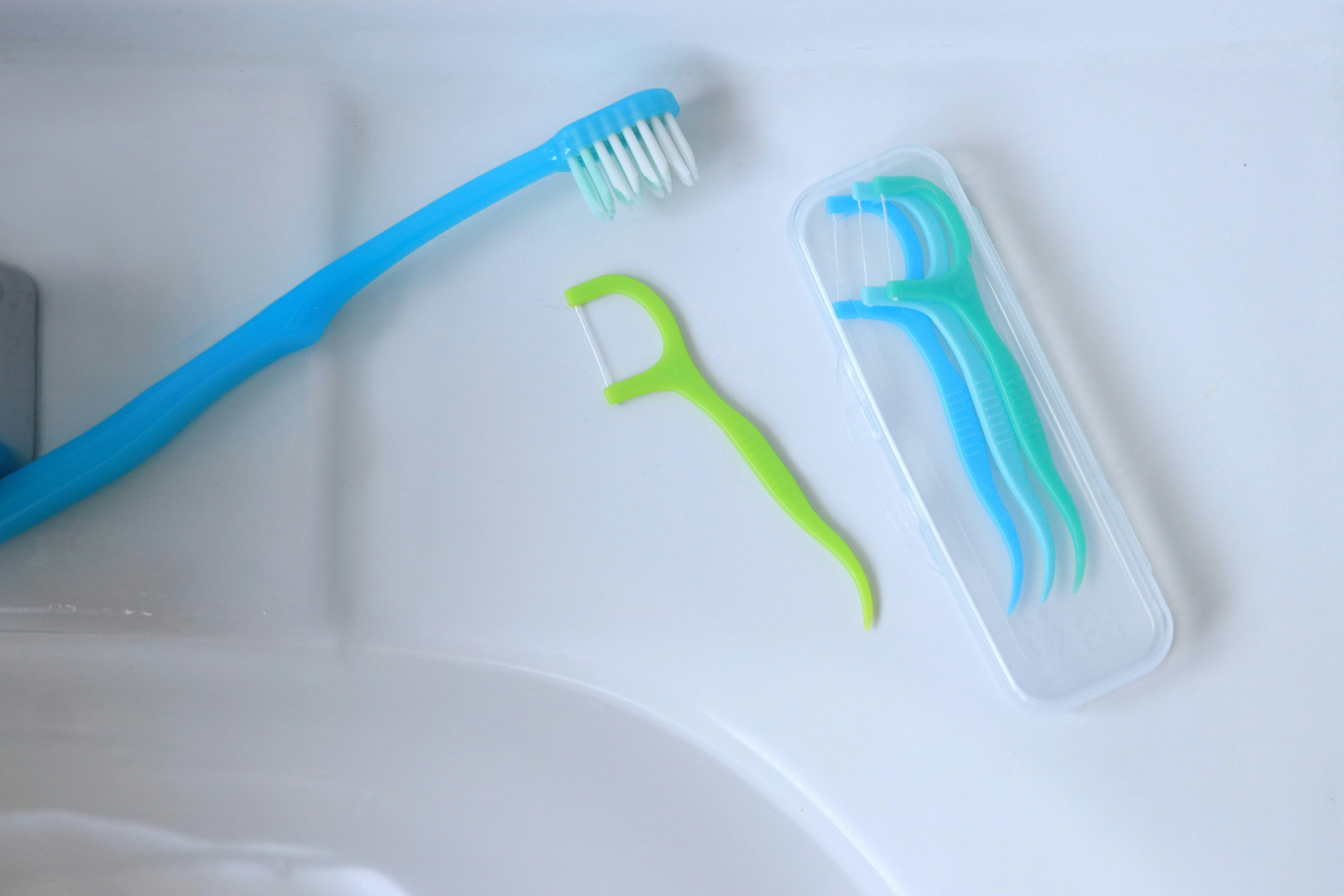 brosses à dents et dentifrice sur un lavabo de salle de bain