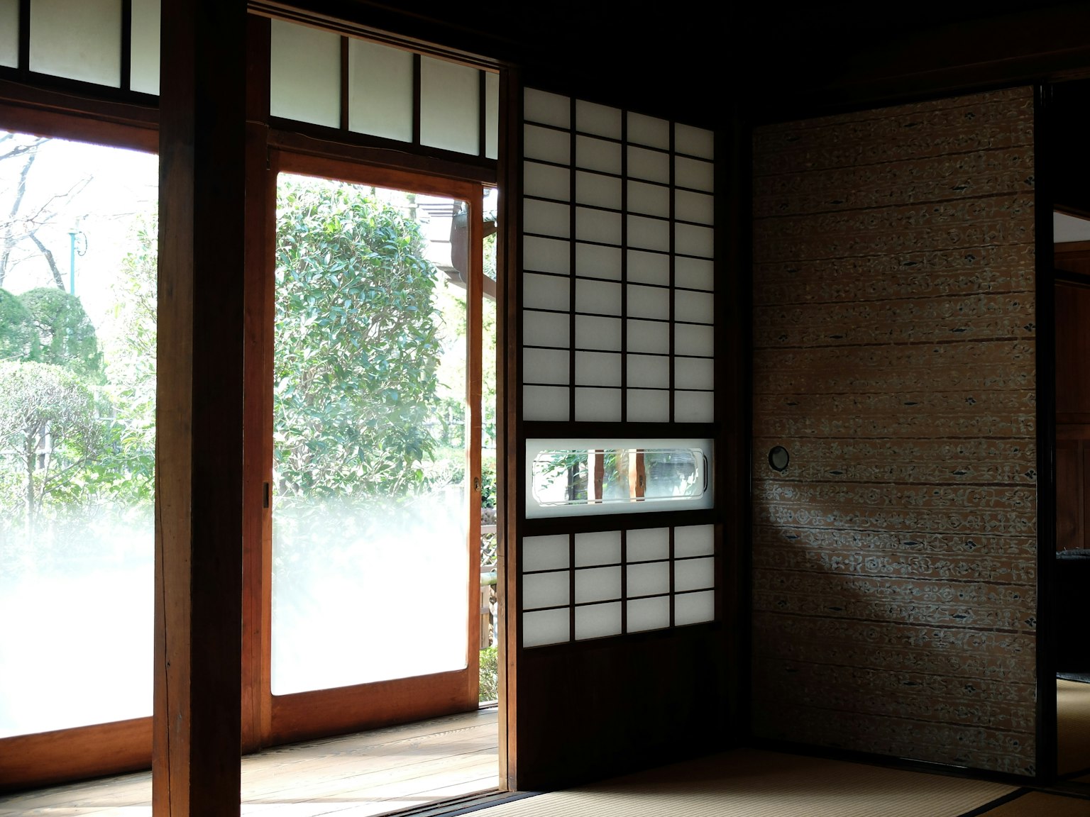 Intérieur d'une pièce japonaise traditionnelle avec des portes en bois et une vue sur le jardin