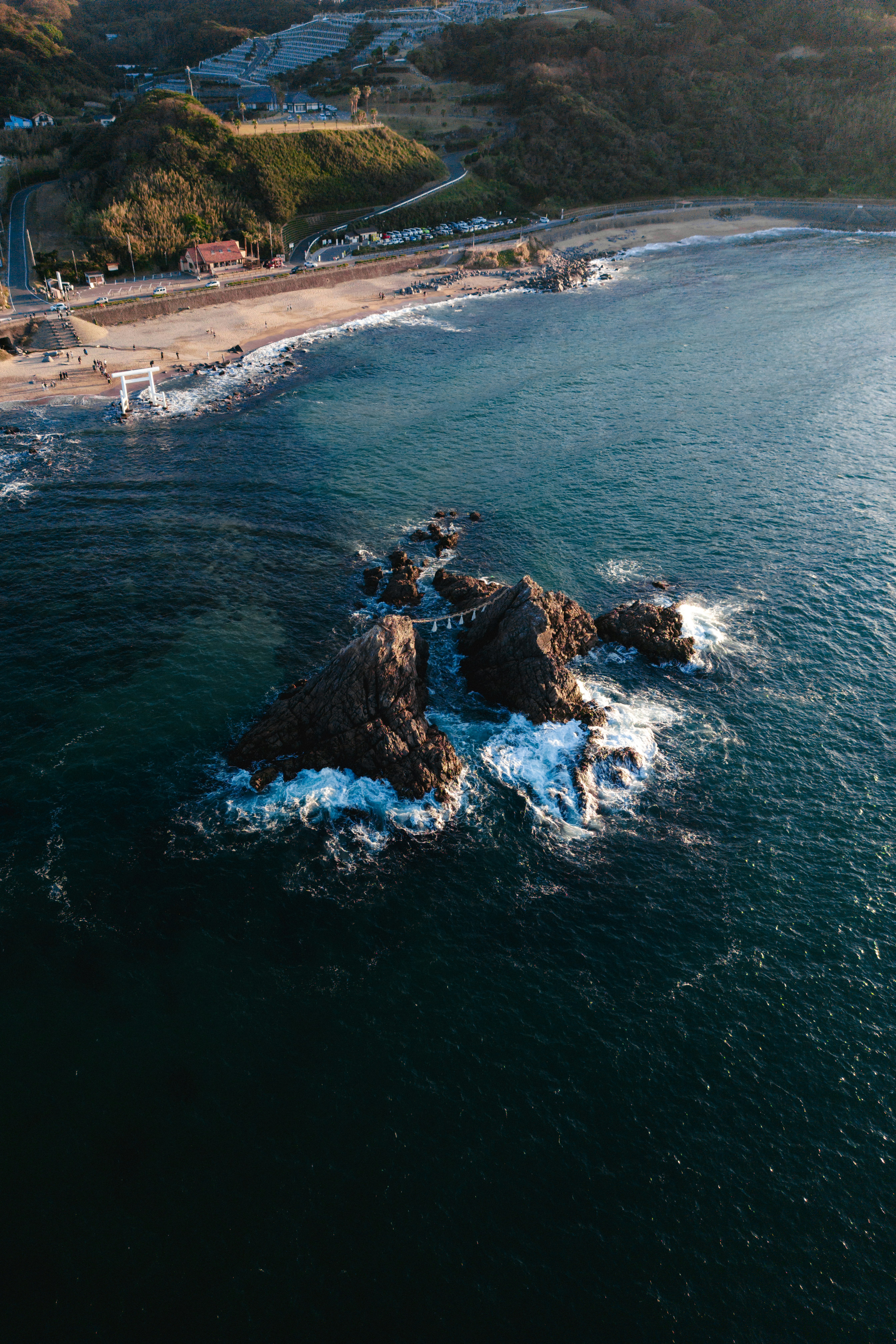 岩石海岸上巨浪拍打的灯塔与防波堤景观