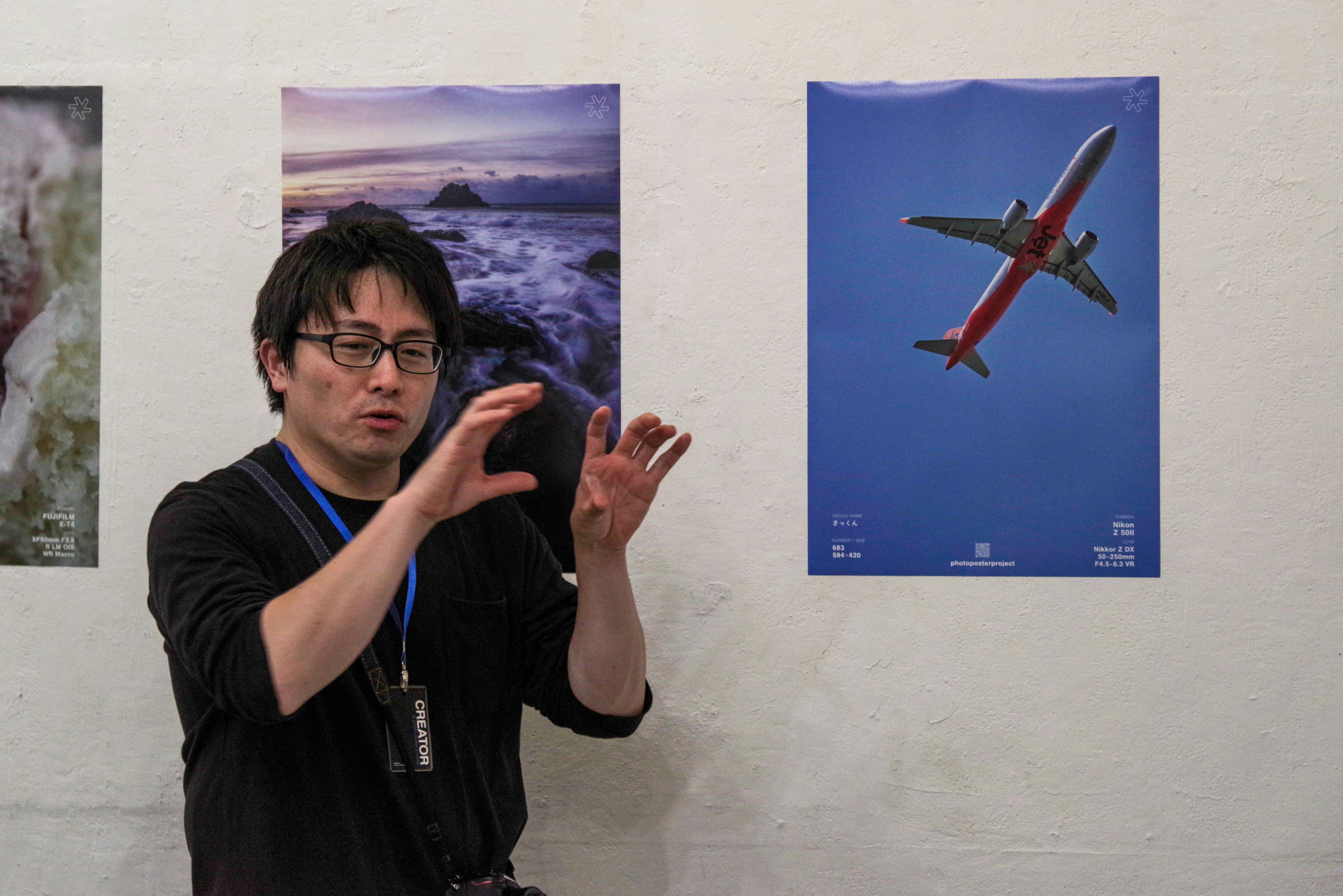 東京のギャラリーで壁に展示されたポスターと人物のスナップ