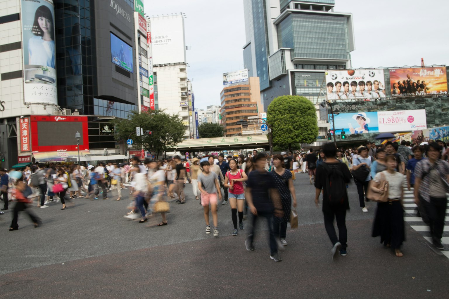Busy Shibuya Crossing with pedestrians and urban buildings