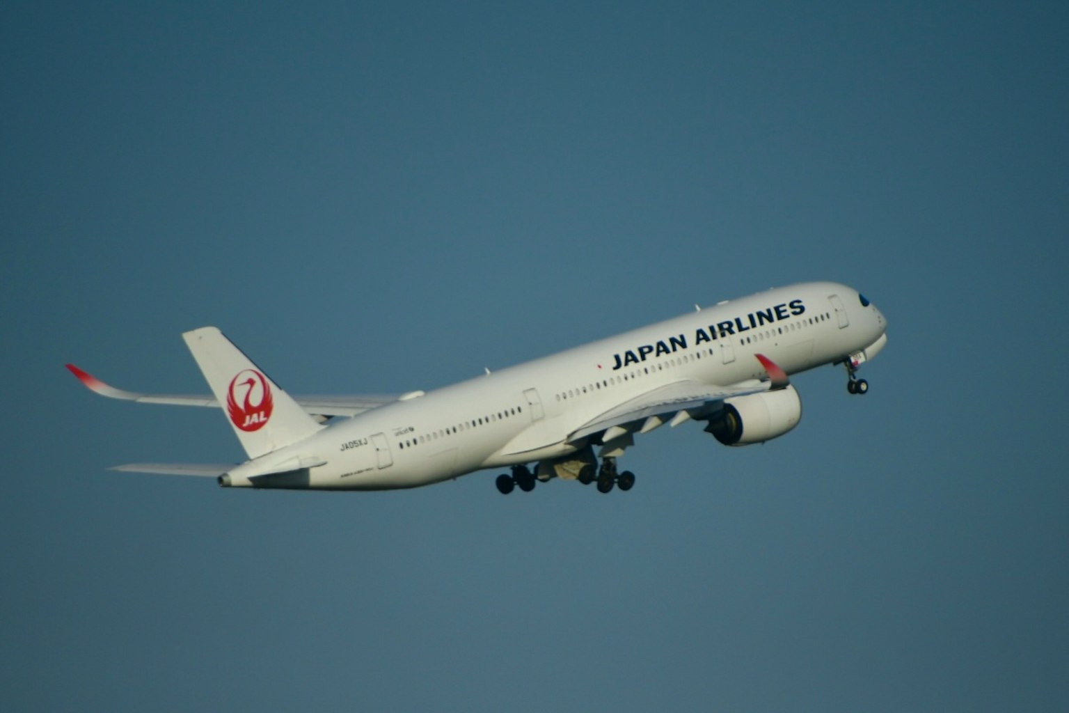 Pesawat Japan Airlines lepas landas di langit cerah