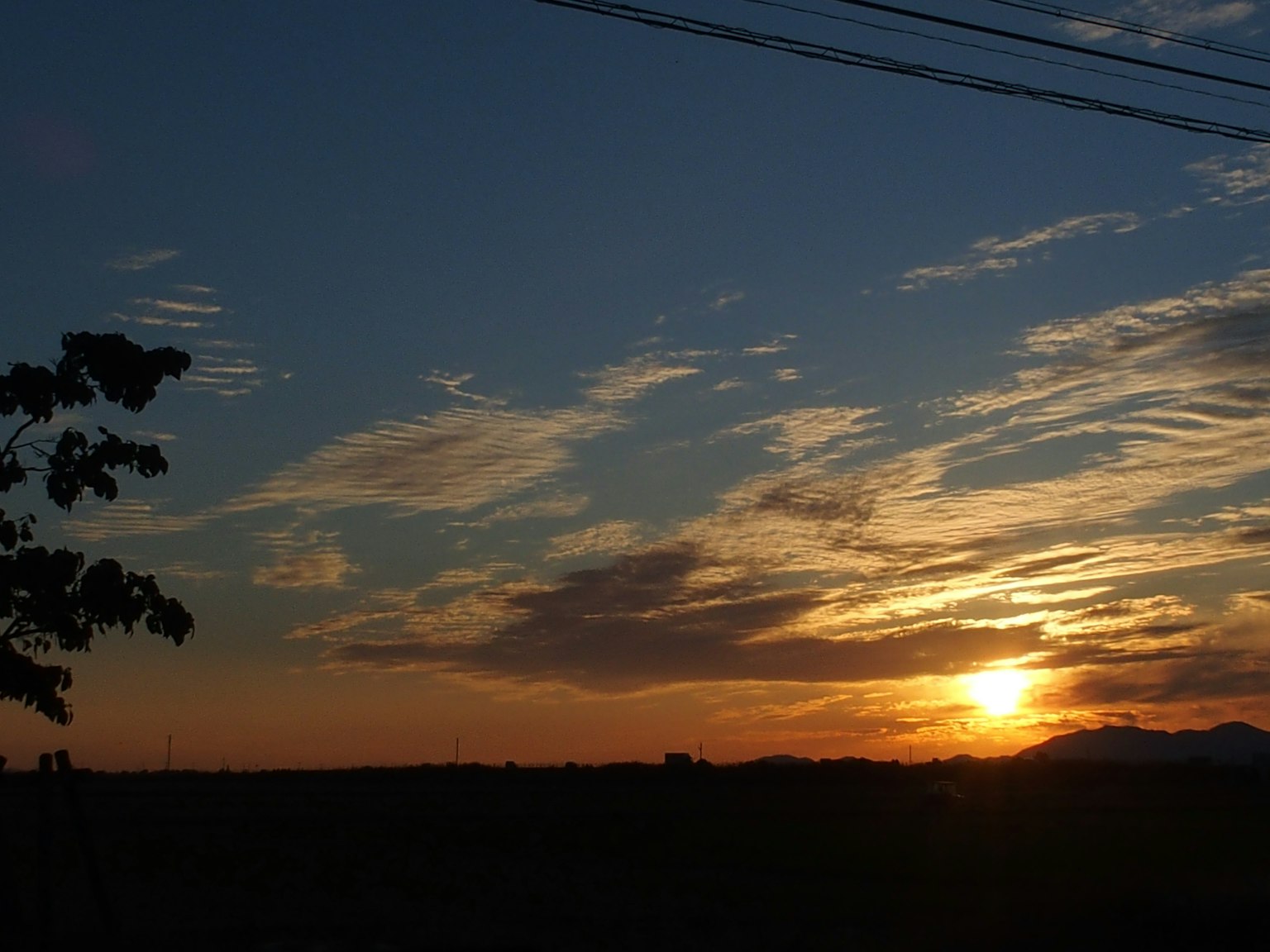 夕焼けの空と山々のシルエットが美しい風景