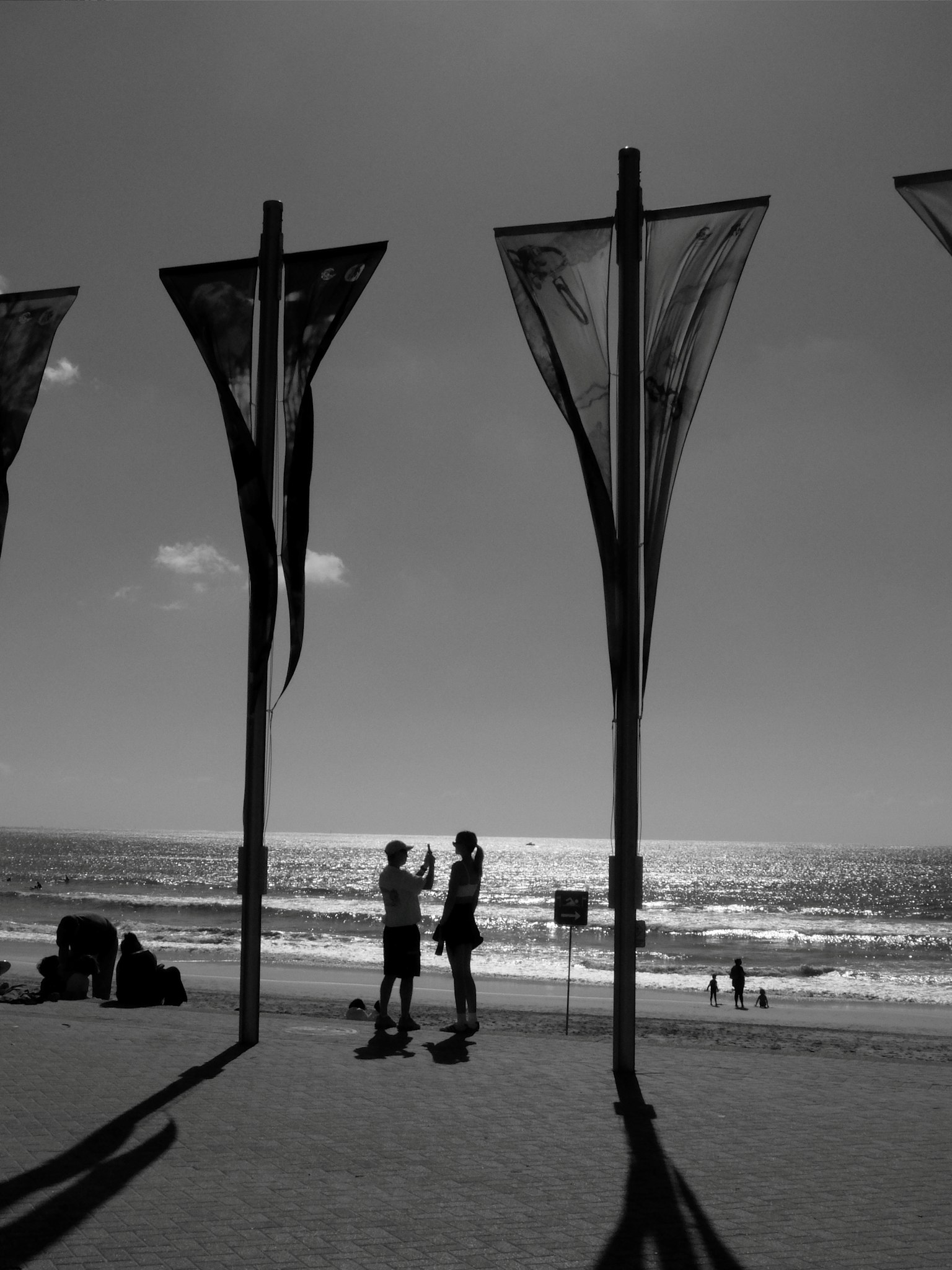 Silhouette eines Paares am Strand mit Flaggen im Vordergrund