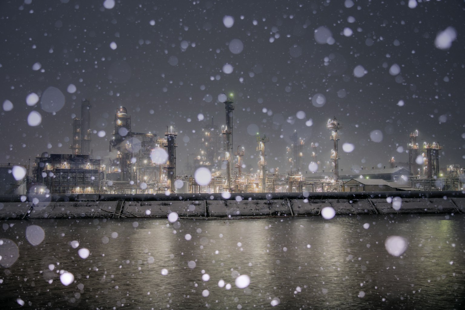 Nachtansicht eines Industriegebiets mit fallendem Schnee