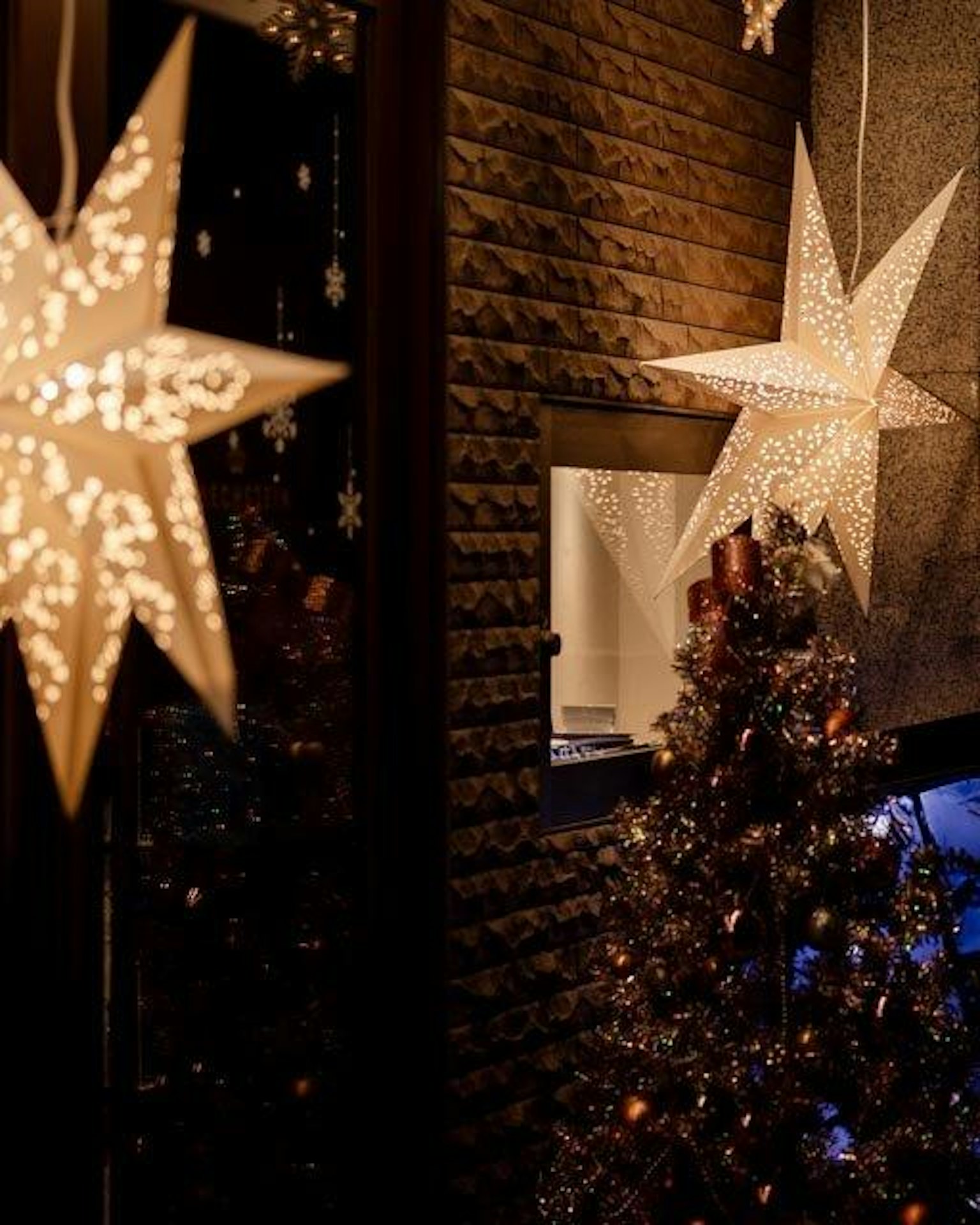 Escena interior acogedora con un árbol de Navidad y luces decorativas en forma de estrella