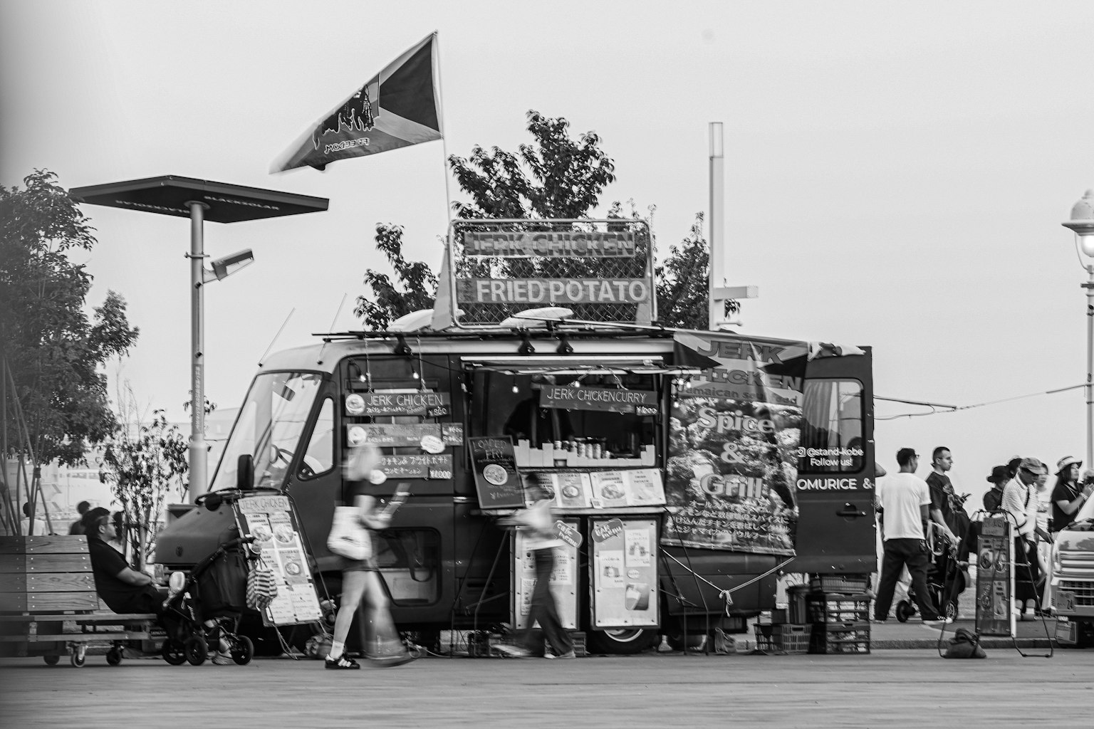 Image en noir et blanc d'un camion de nourriture avec des gens interagissant