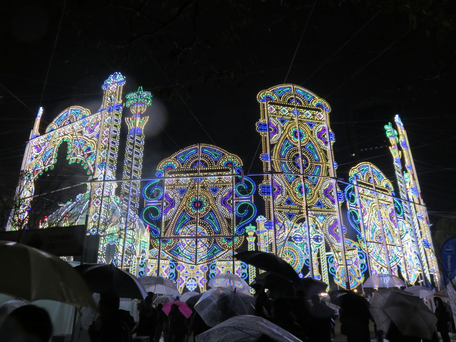 夜間照明的建築和拿著傘的人們