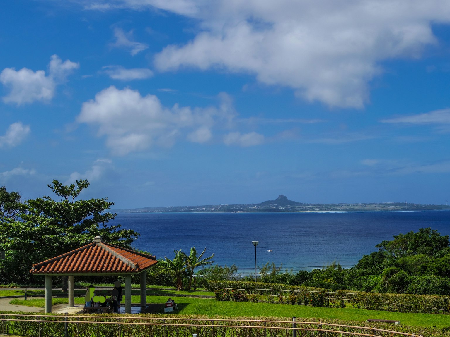 Pavilion overlooking the ocean with lush greenery and blue sky
