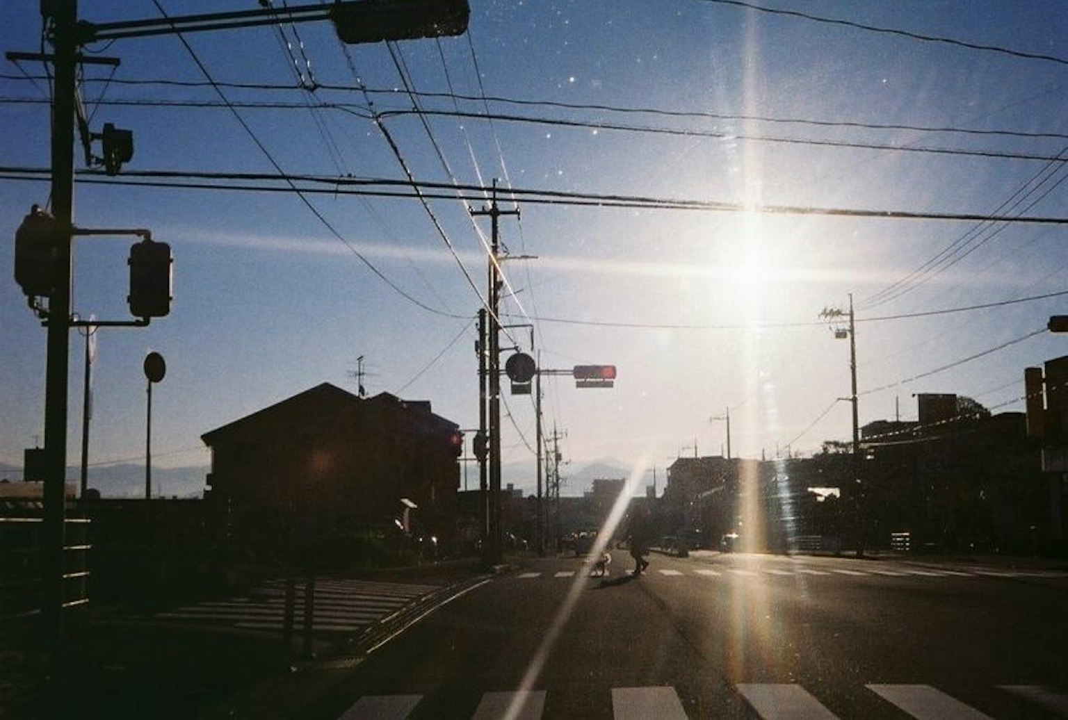 夕日が輝く交差点の風景 電線と信号機が見える