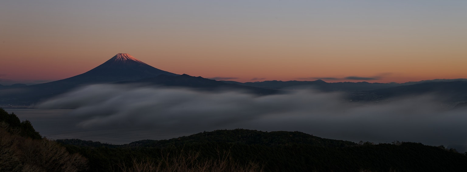 Silhouette d'une montagne contre un beau coucher de soleil avec mer de nuages