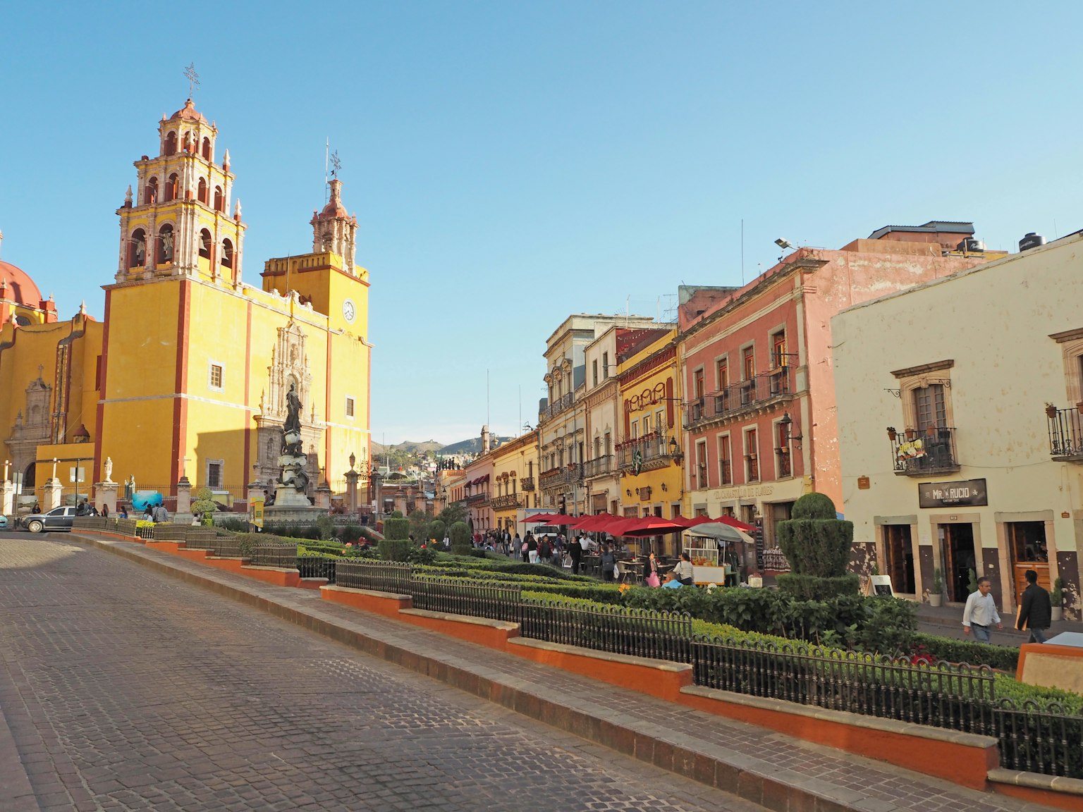 Lebendige Straßenszene in Guanajuato mit bunten Gebäuden und einer markanten Kirche
