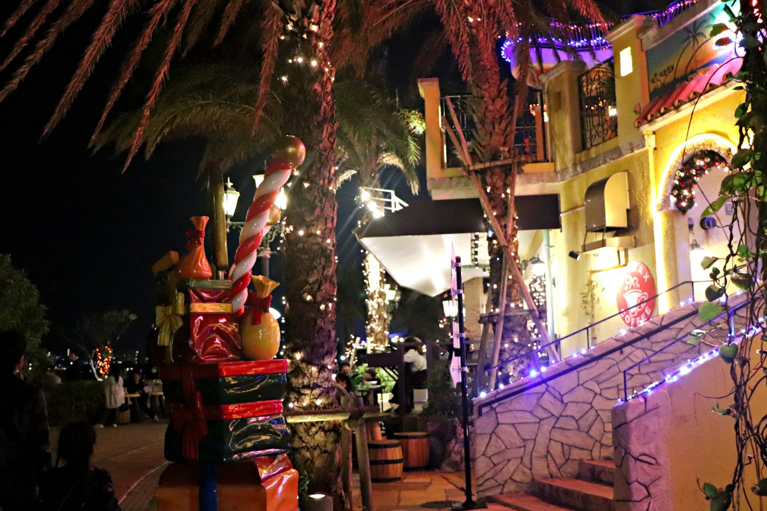 Edificio colorato decorato per la notte con luci vivaci e palme
