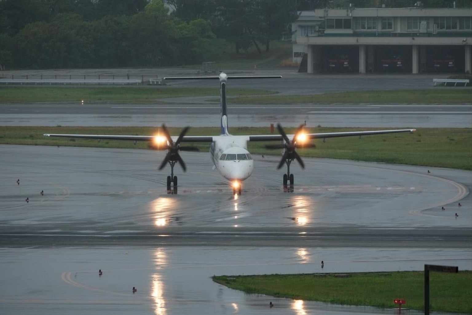 Aereo a elica sulla pista sotto la pioggia