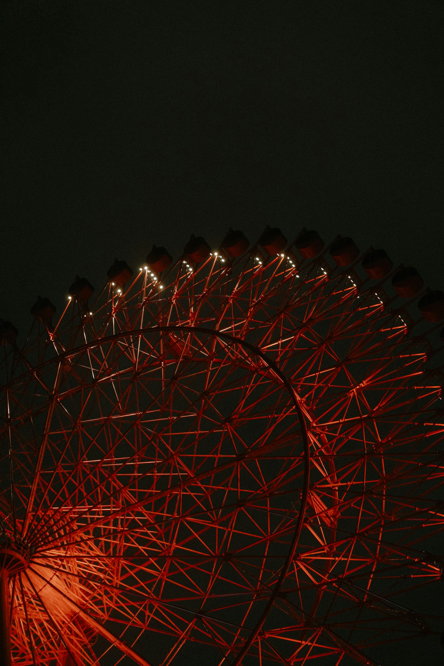夜空中红色摩天轮的照片，发出明亮的光