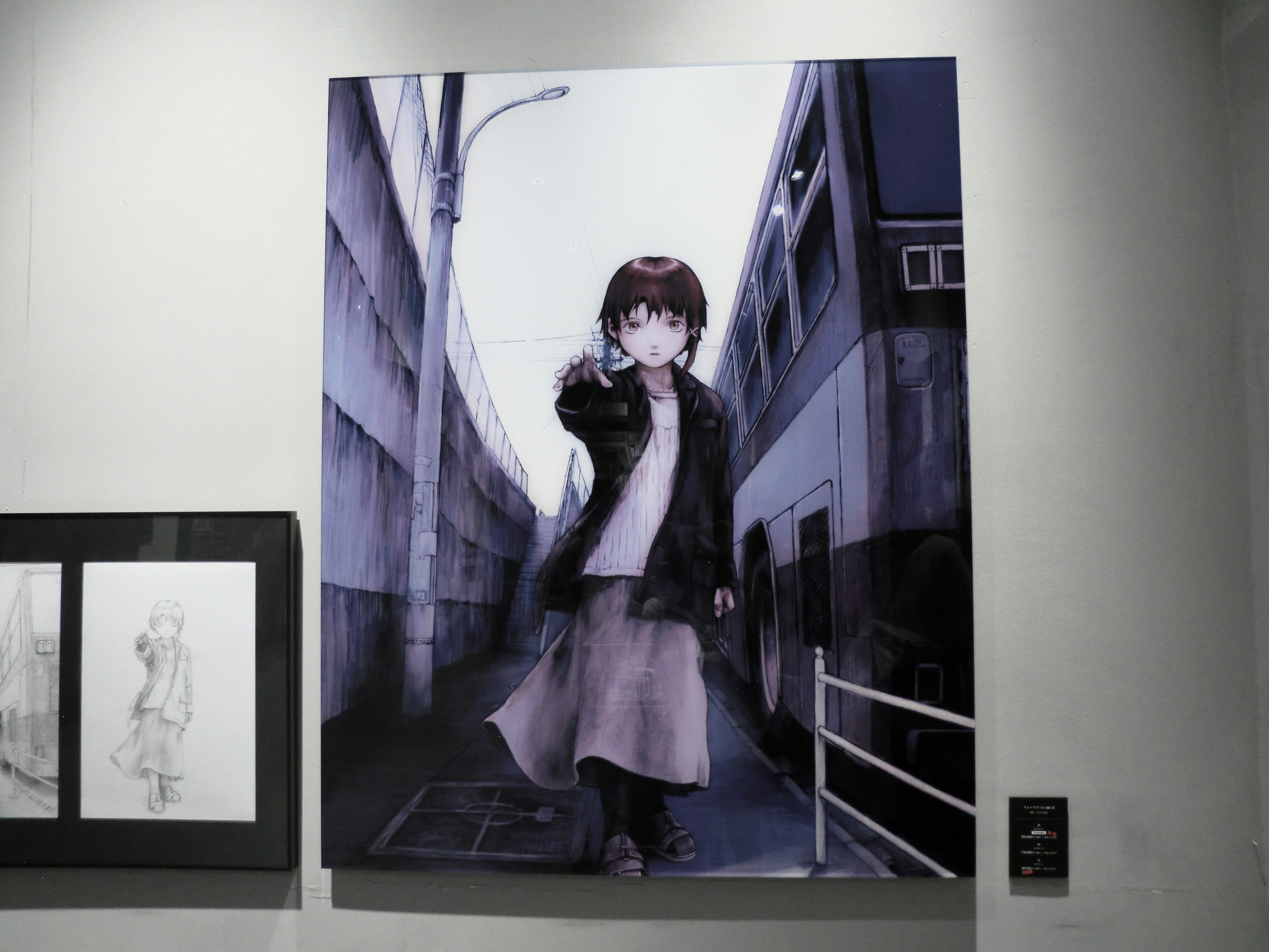 壁に掛けられたアニメスタイルの絵画で、少女が指を指している