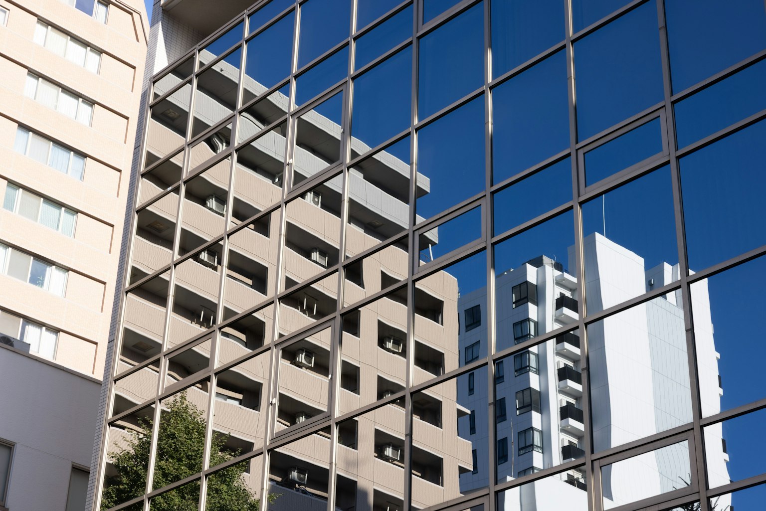 Reflet des bâtiments et du ciel bleu dans la façade en verre