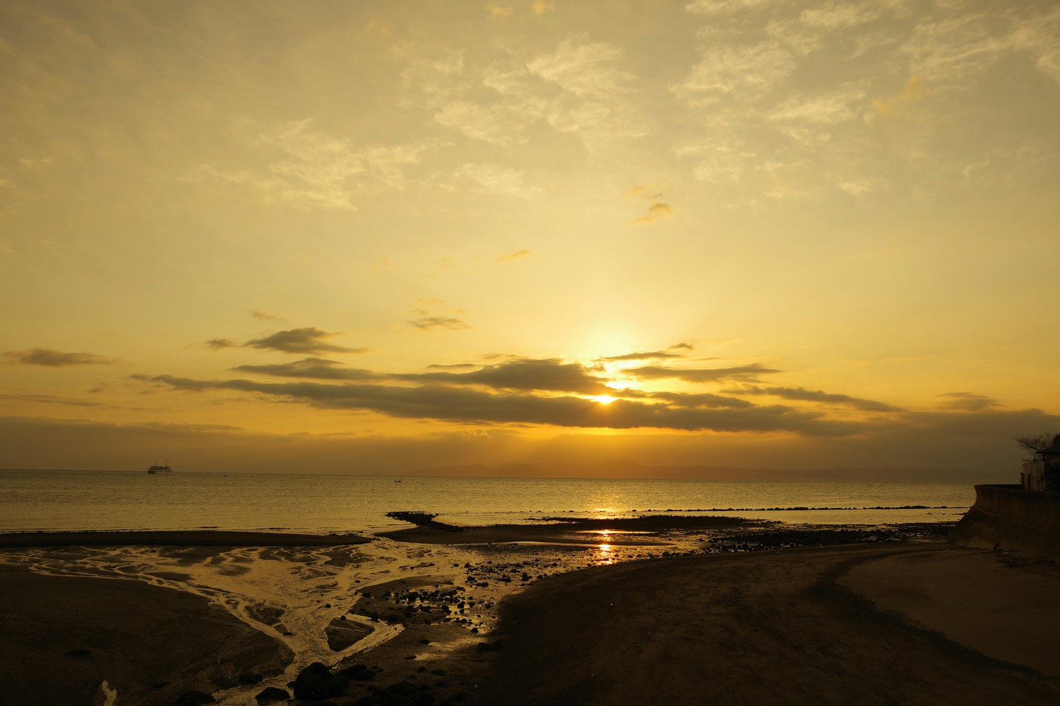 Pemandangan matahari terbenam yang indah di pantai dengan awan lembut dan air tenang