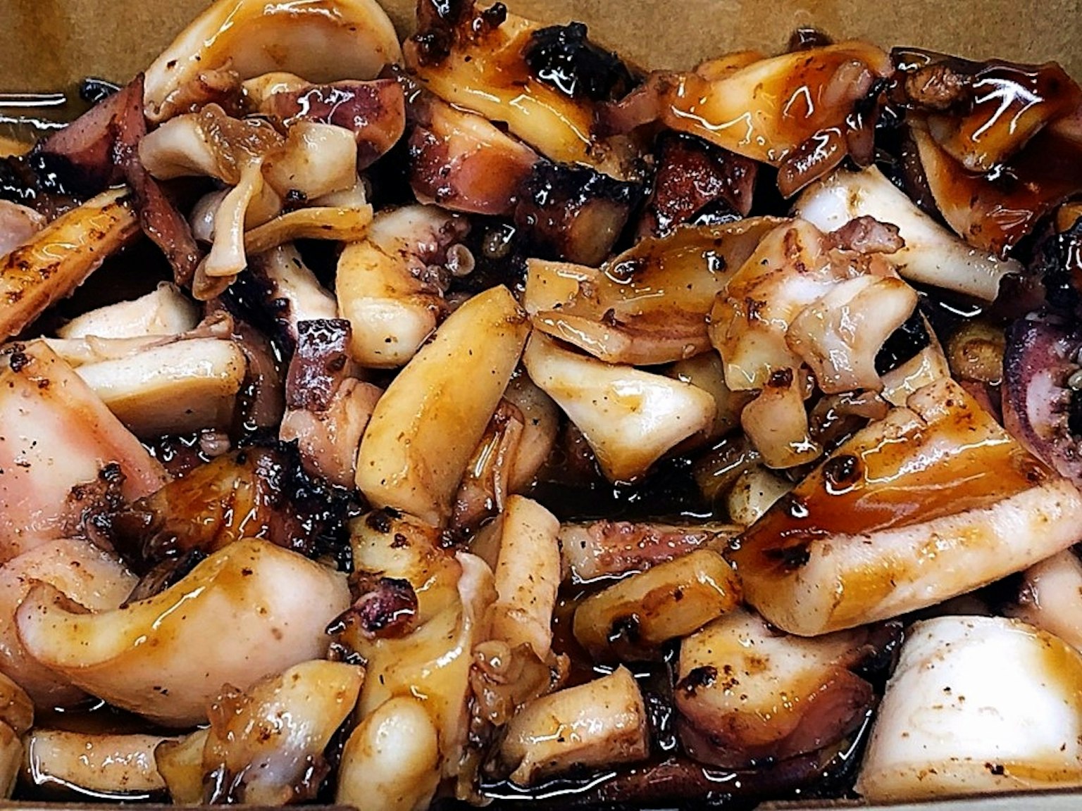 Un plato con una generosa porción de trozos de calamar a la parrilla