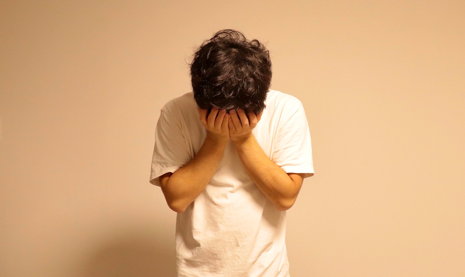 Un hombre sosteniendo su cabeza con angustia