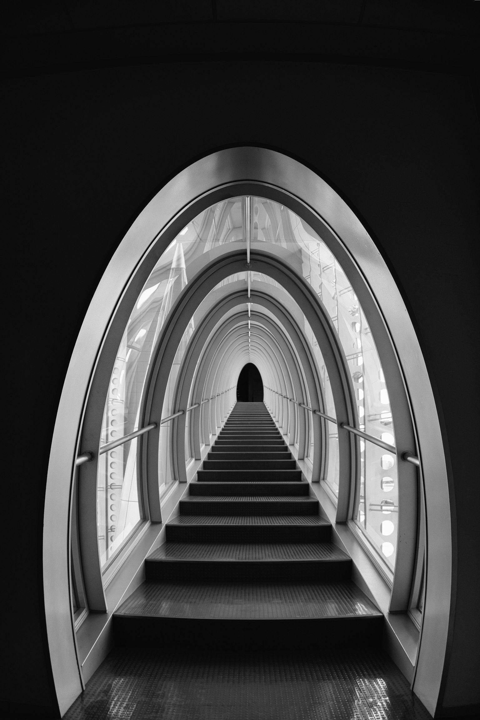 Image of an arched hallway with stairs in black and white