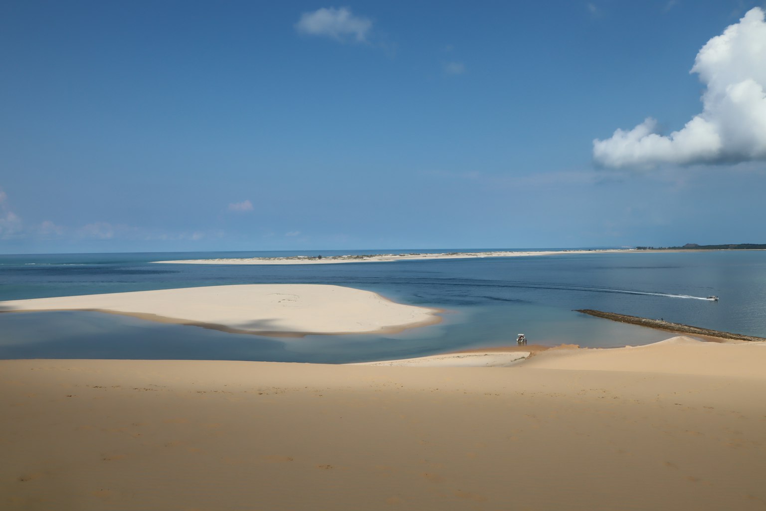 Pemandangan indah pantai berpasir dikelilingi langit biru dan laut tenang