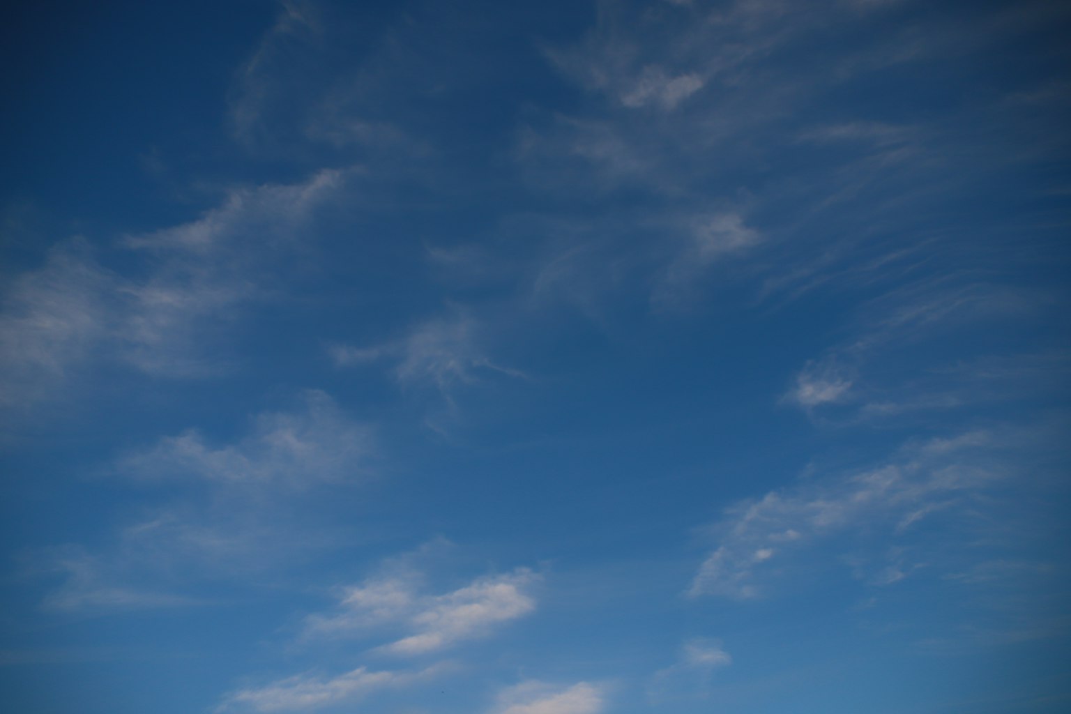 Ein blauer Himmel mit verstreuten dünnen Wolken