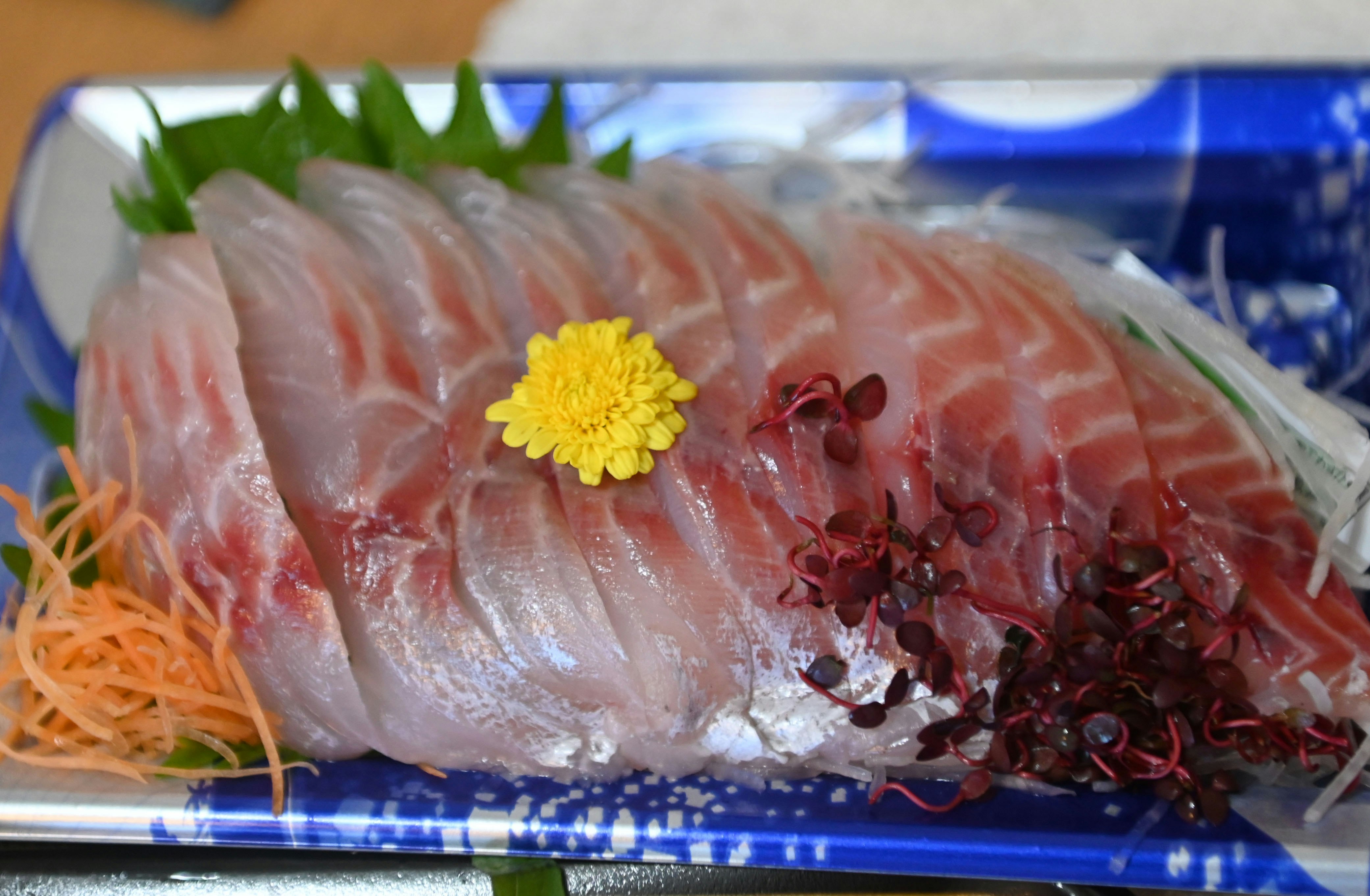 sashimi-style salmon on a platter with chopped garnishes