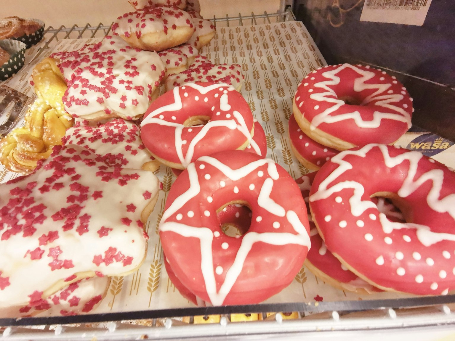 Vetrina di ciambelle con glassa rossa e bianca e dolci a forma di stella