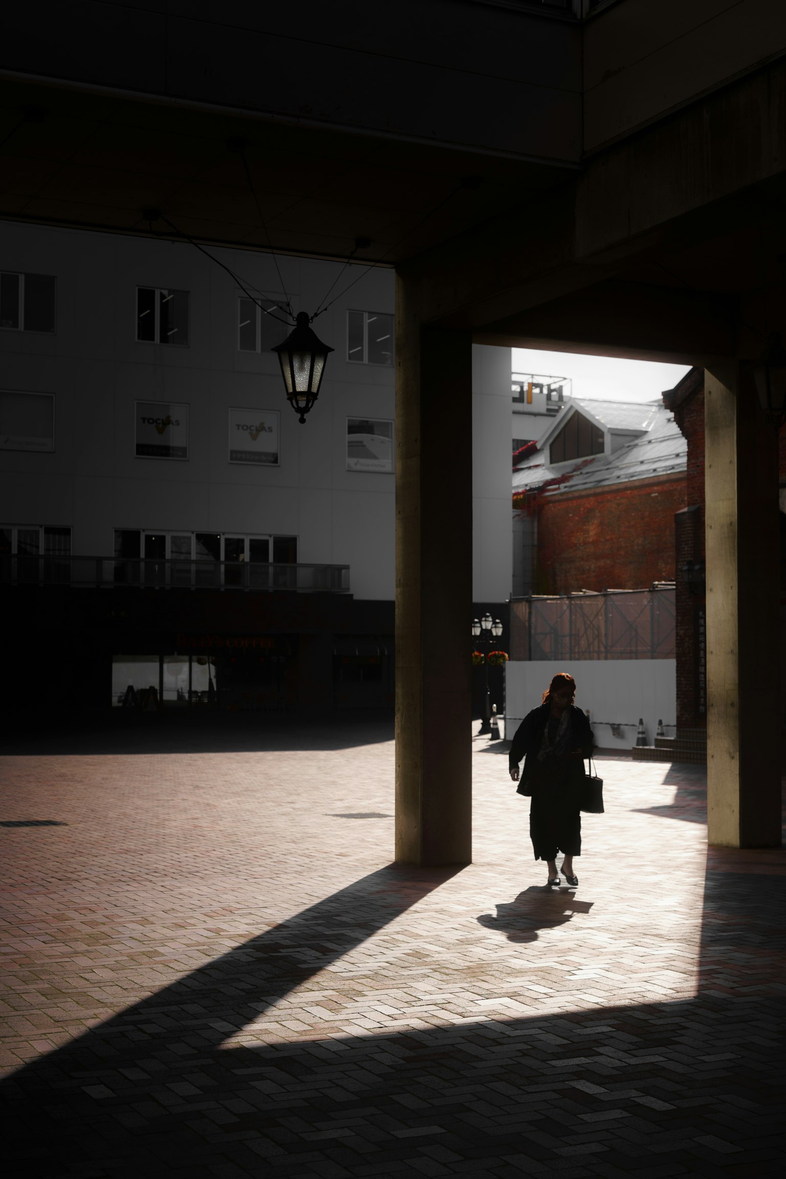 Silhouette d'une personne marchant sous une arche Contraste de lumière et d'ombre
