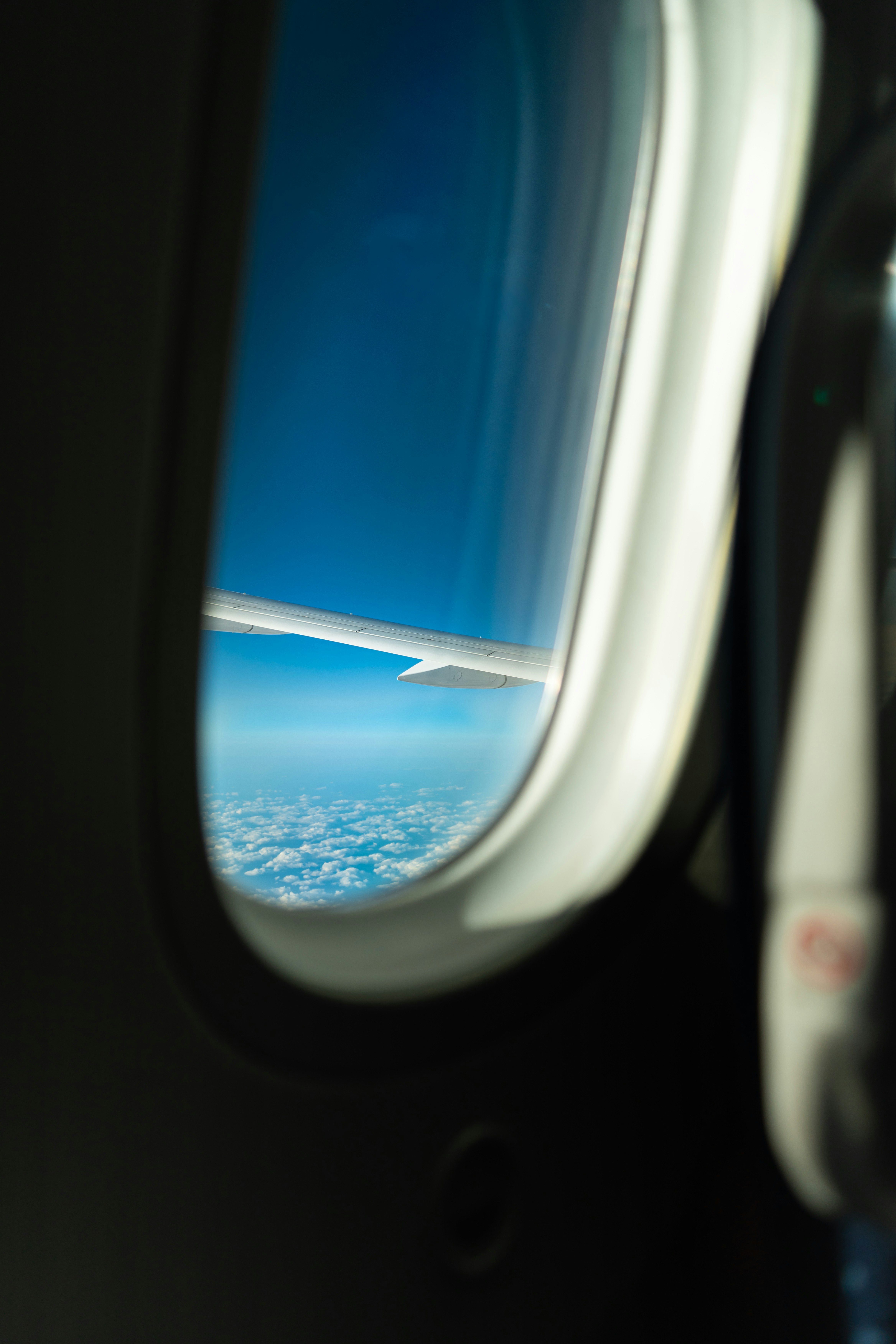飛行機の窓から見える青い空と雲の広がり