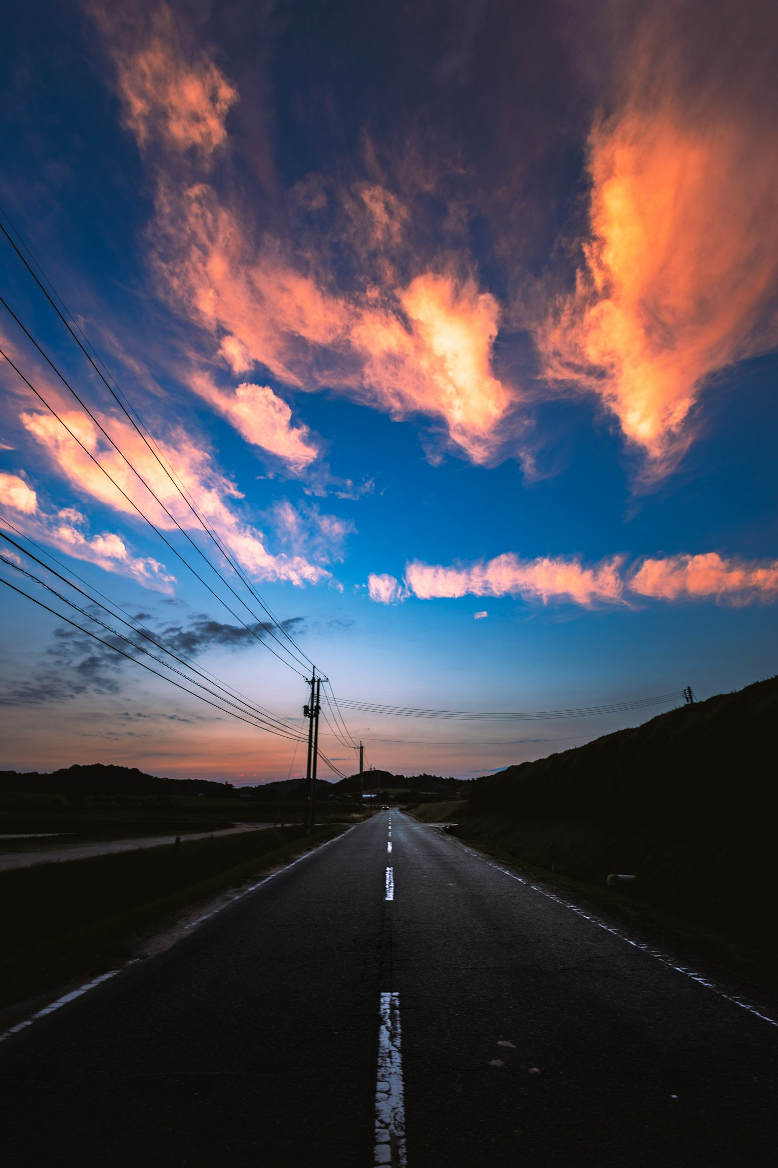 Paesaggio con una strada sotto un cielo al tramonto