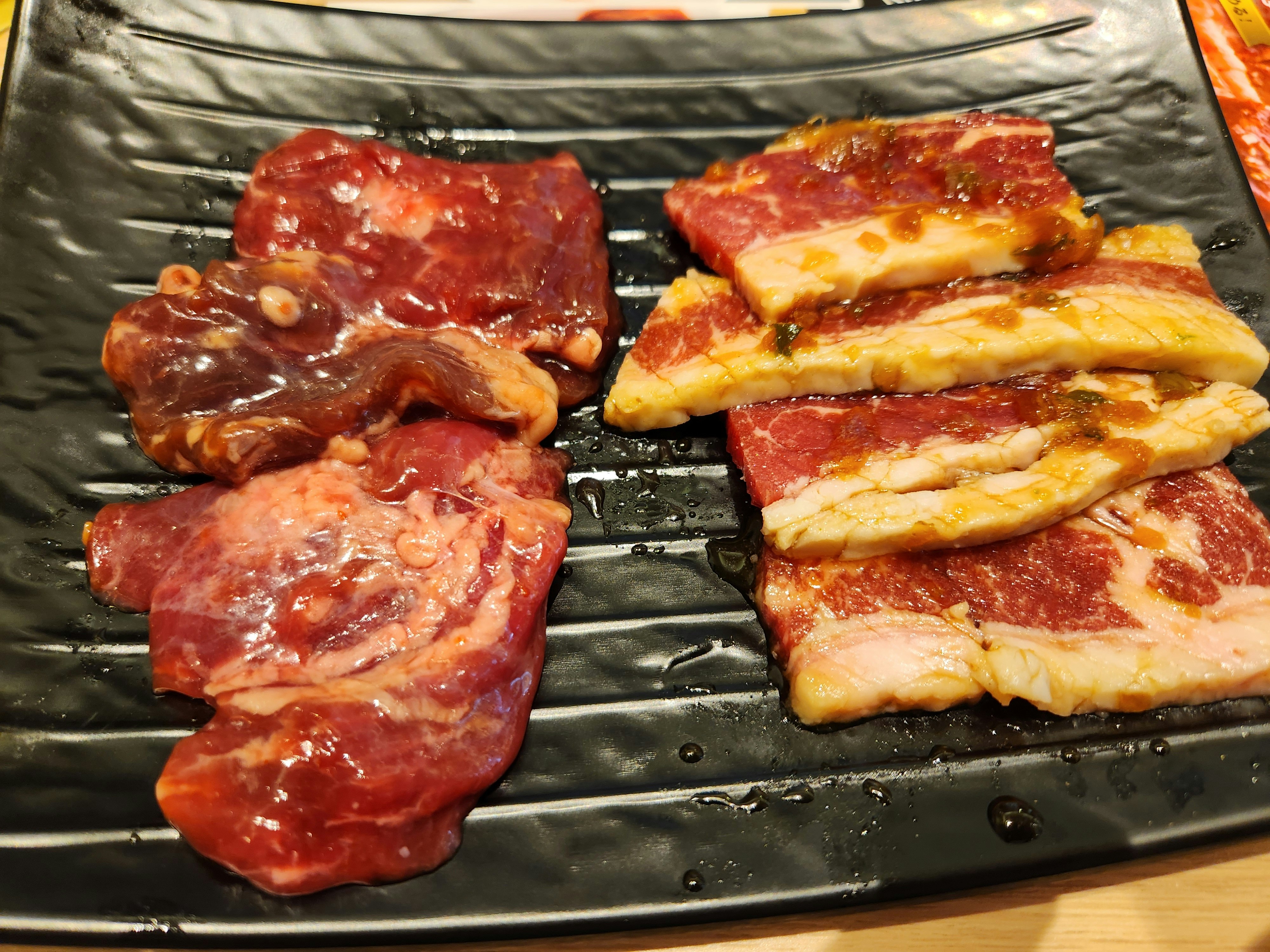 Tocino y carne gruesa a la plancha sobre una placa caliente