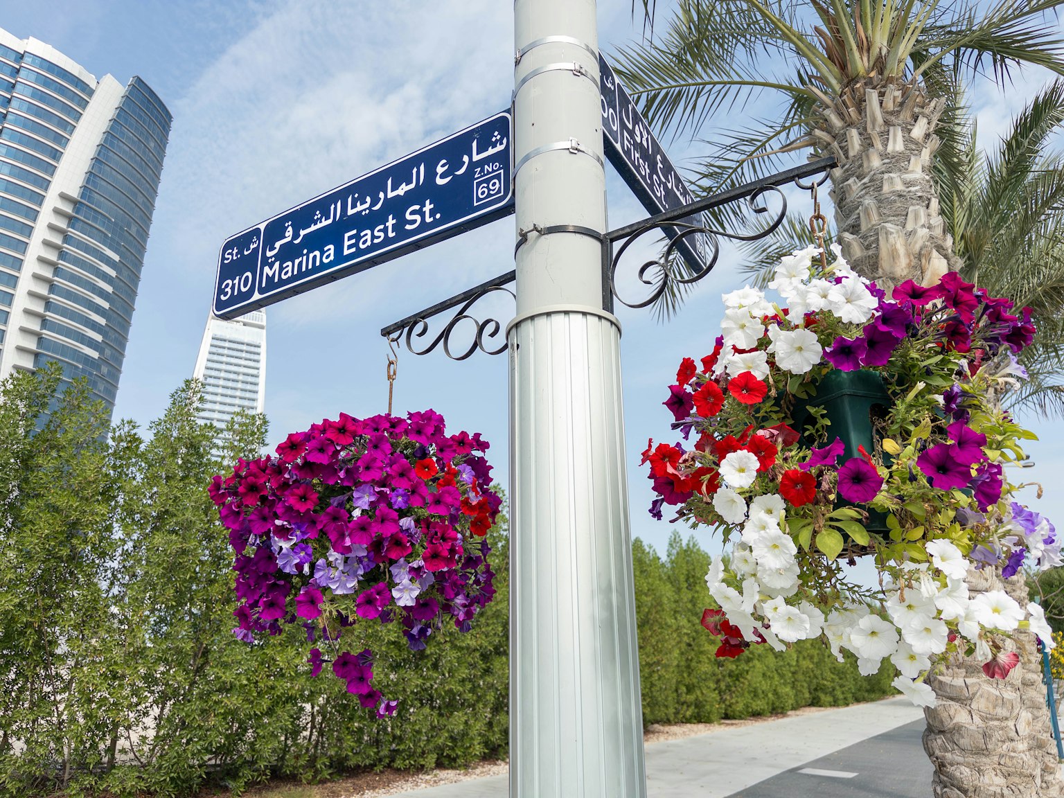 Señal de calle con flores colgantes coloridas