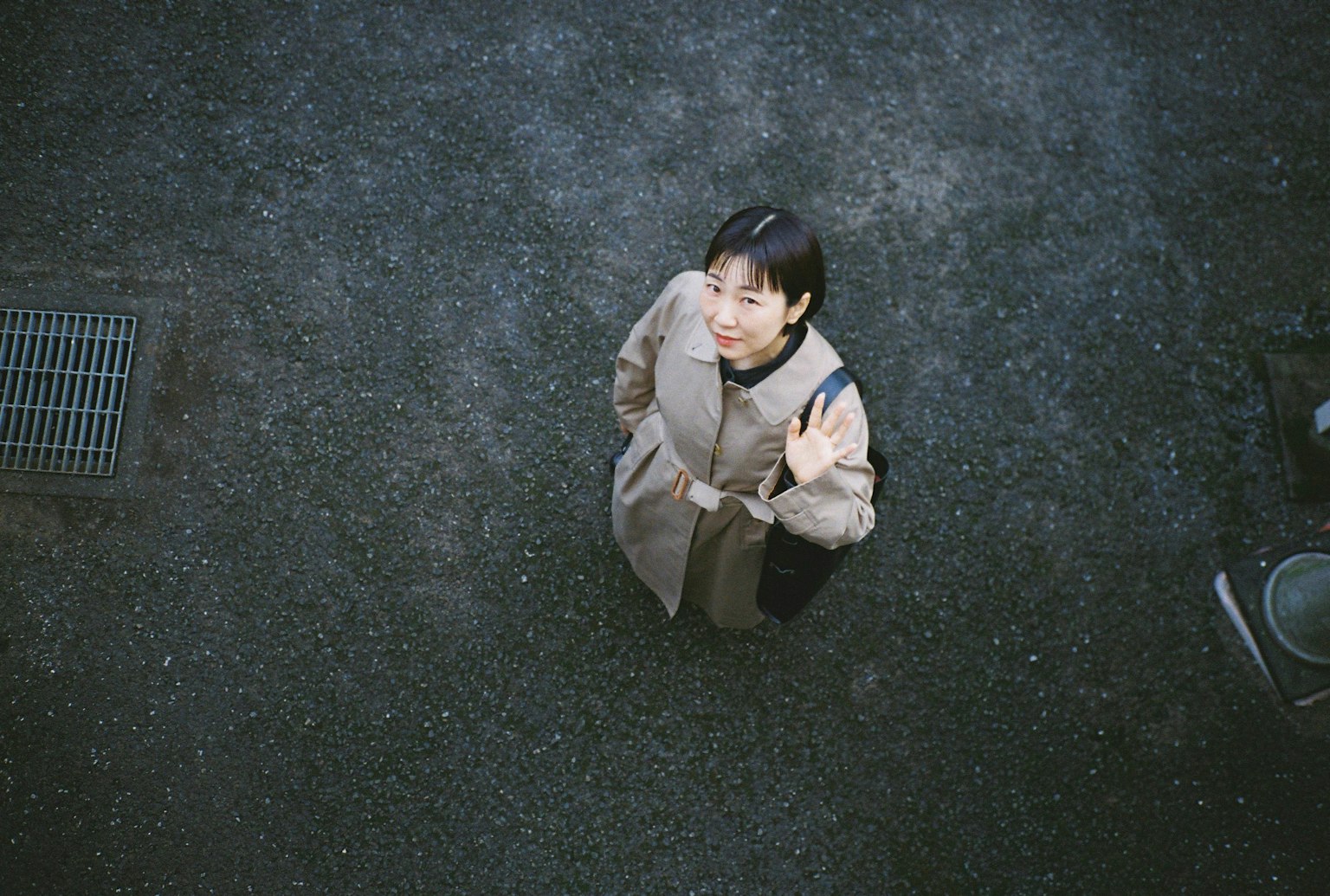 上から見た女性が微笑んでいる様子と暗い地面