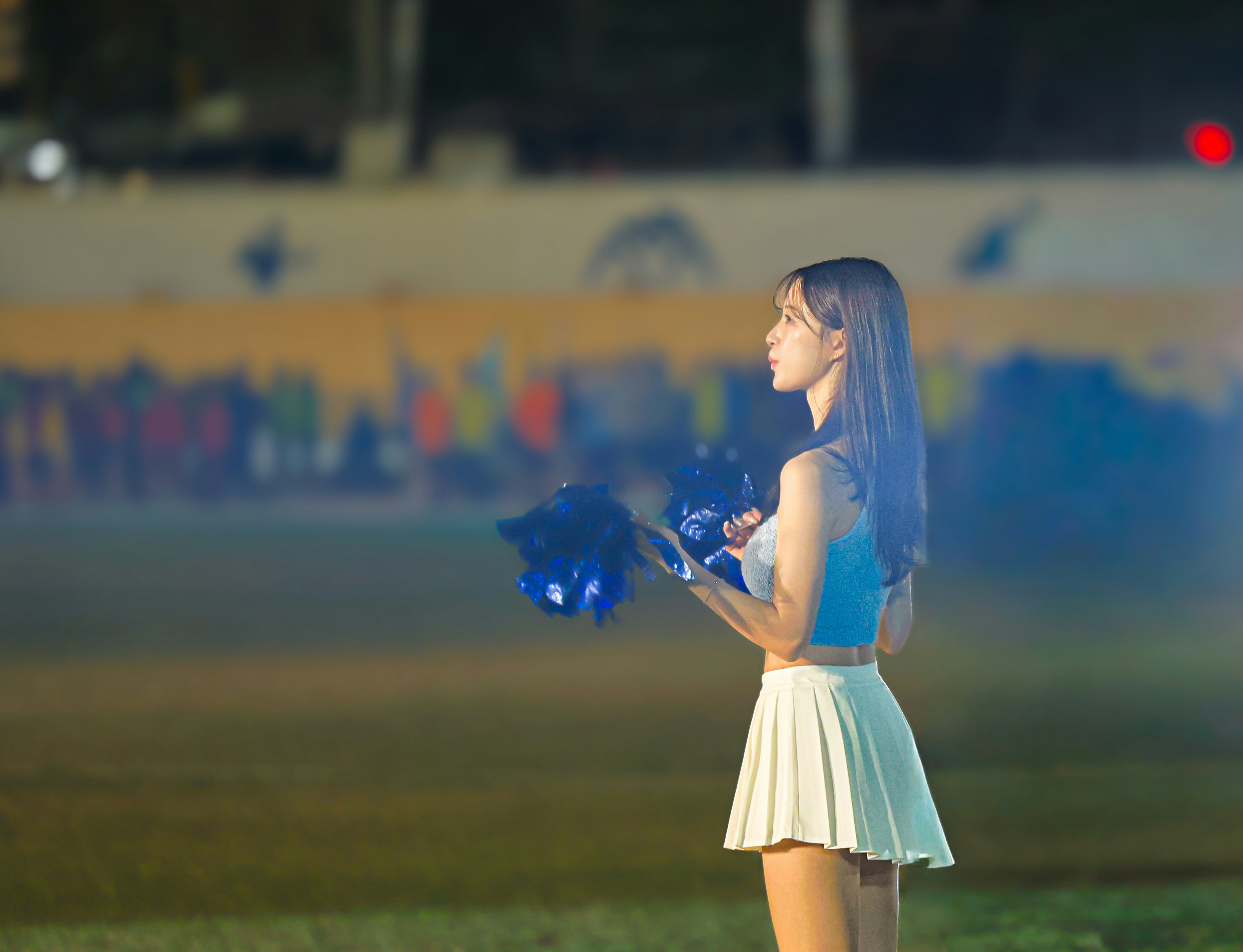 夜の公園で青い光の花束を持つ女性