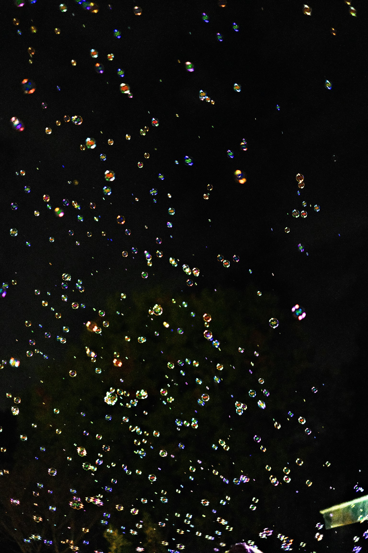 Incontables burbujas de colores flotando en el cielo nocturno