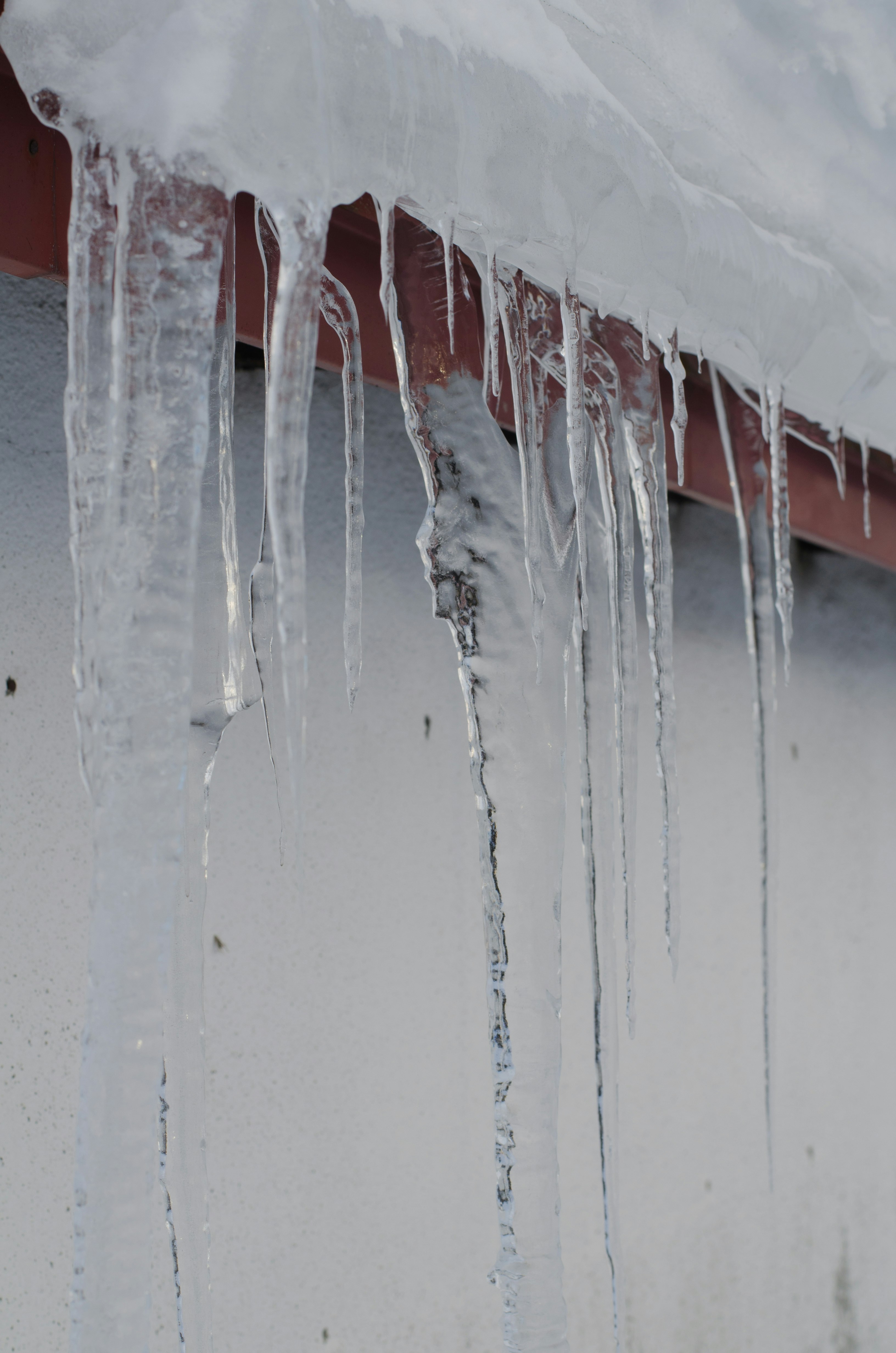 glaçons suspendus sur un mur enneigé