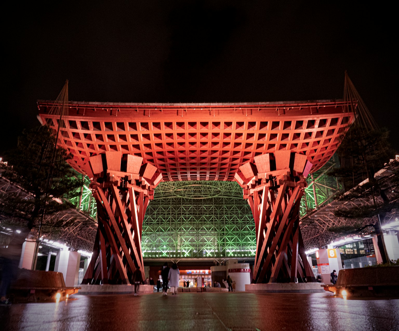 Struktur kayu besar di pintu masuk Museum Seni Kontemporer Abad ke-21 Kanazawa di malam hari