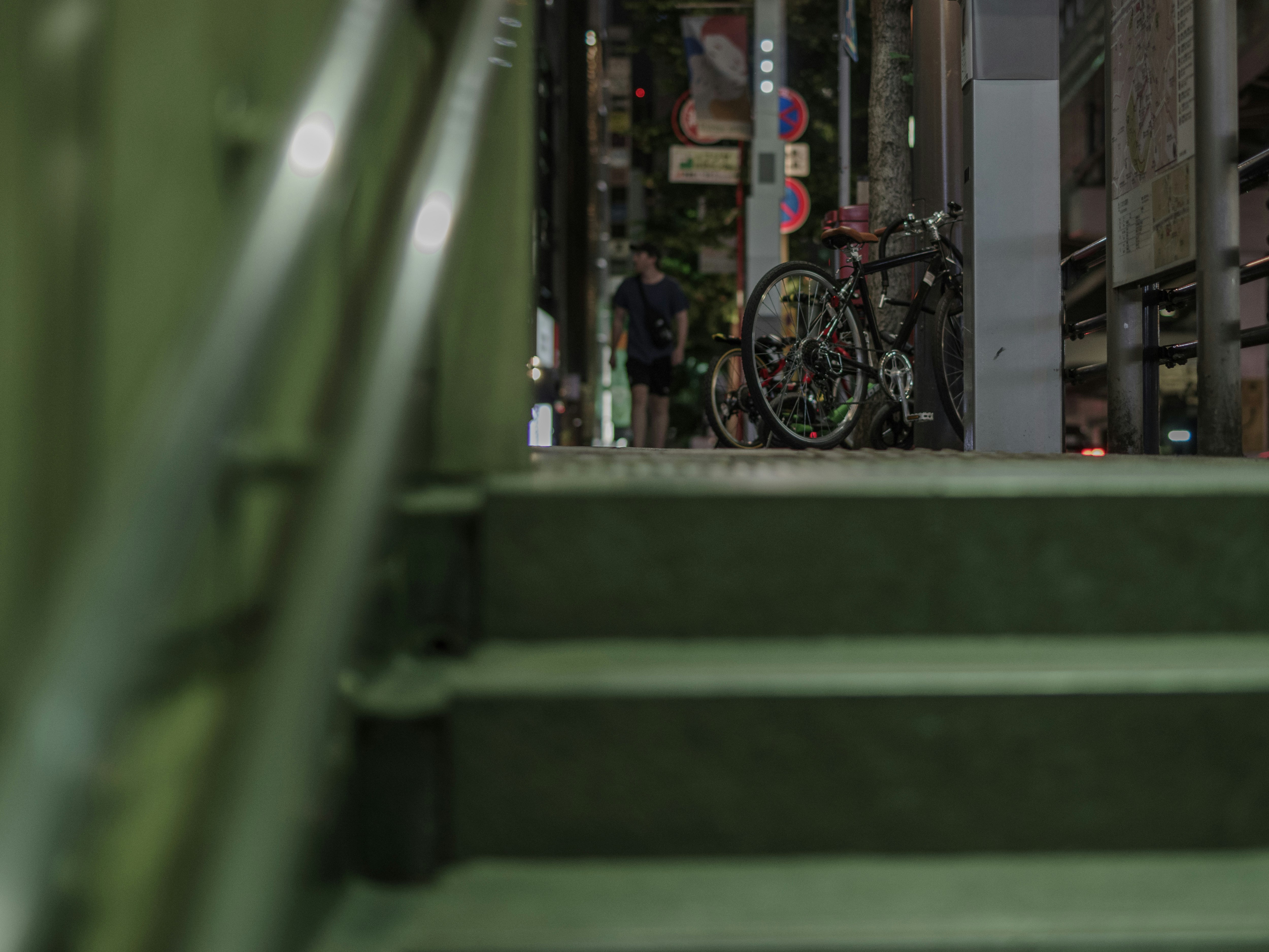 路地の階段脇に並ぶ自転車と街並み