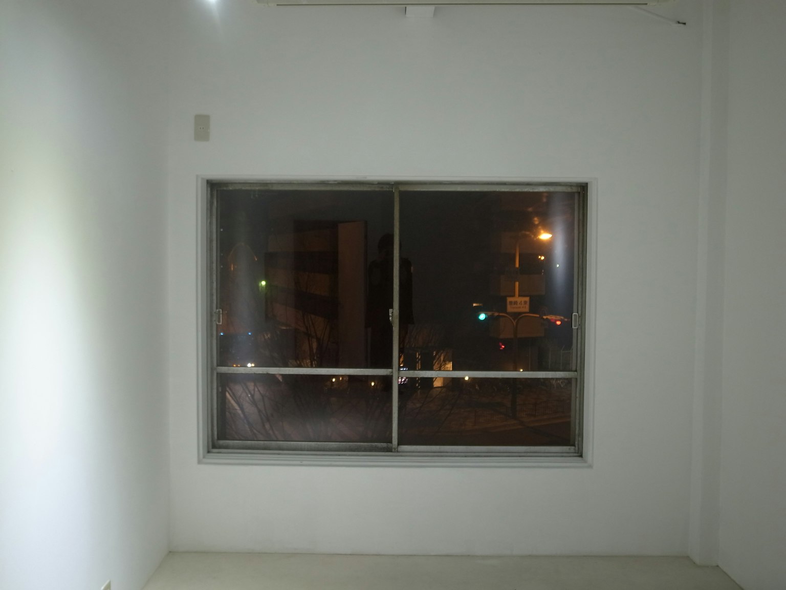 白色房间的窗户映照着夜晚的城市灯光