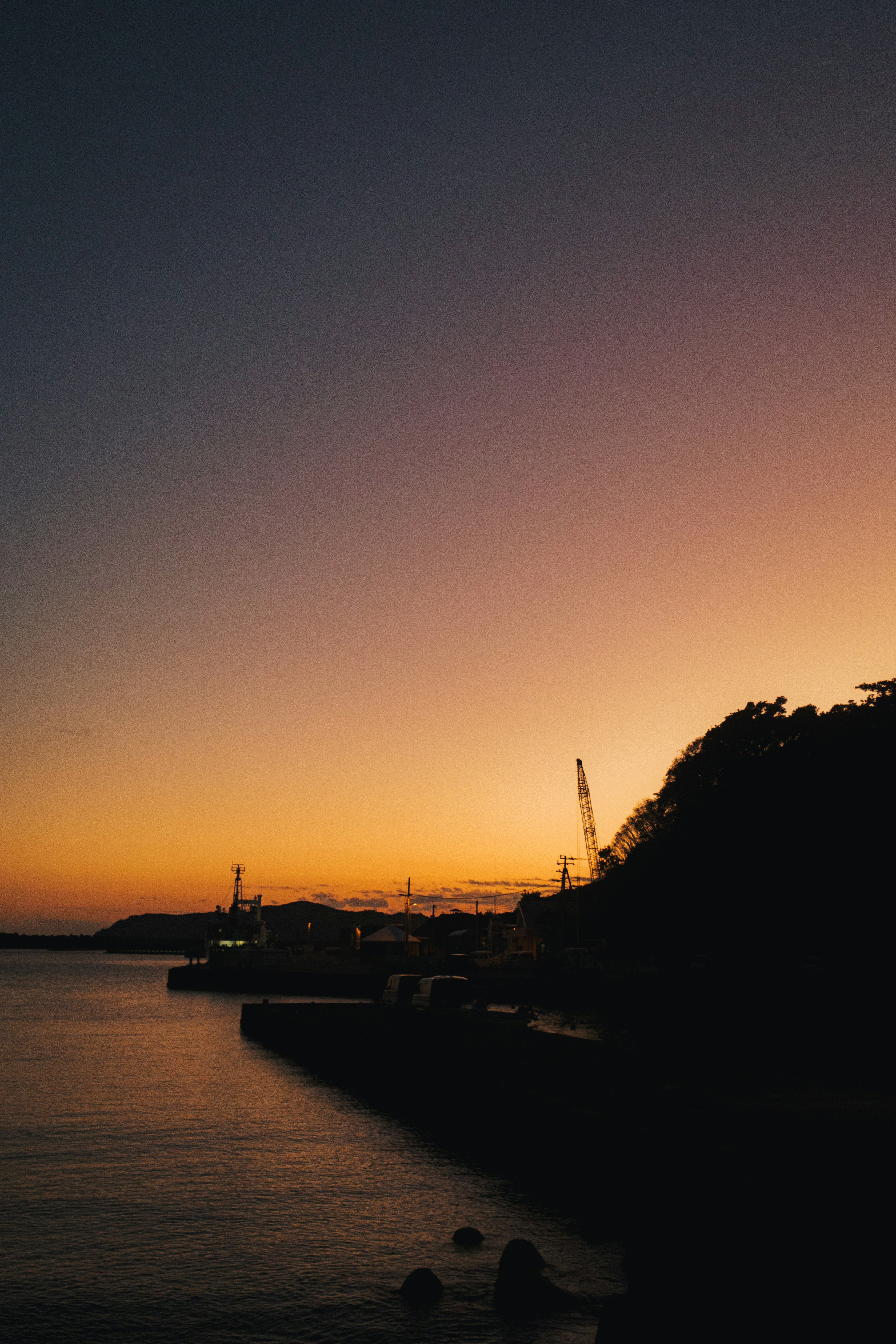 夕暮れの海辺と岸壁のシルエット