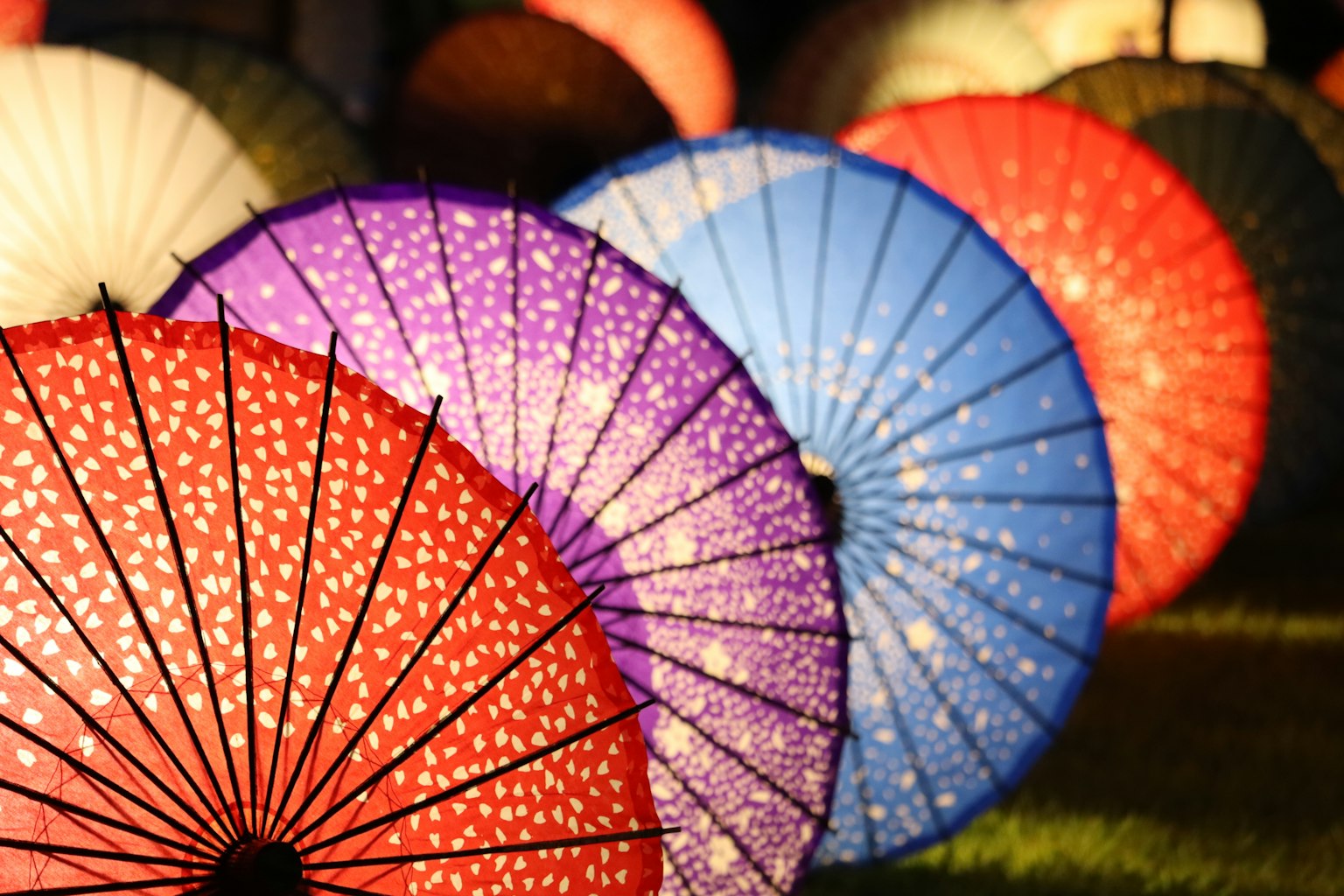 ร่มแบบดั้งเดิมที่มีสีสันเรียงรายในบรรยากาศยามค่ำคืน